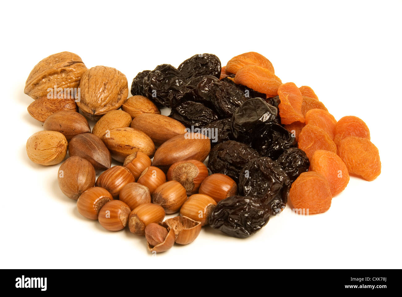 Getrockneten Früchten und Nüssen - Pflaumen, Aprikosen, Haselnüsse, Pekannüsse und Walnüssen isoliert. Stockfoto