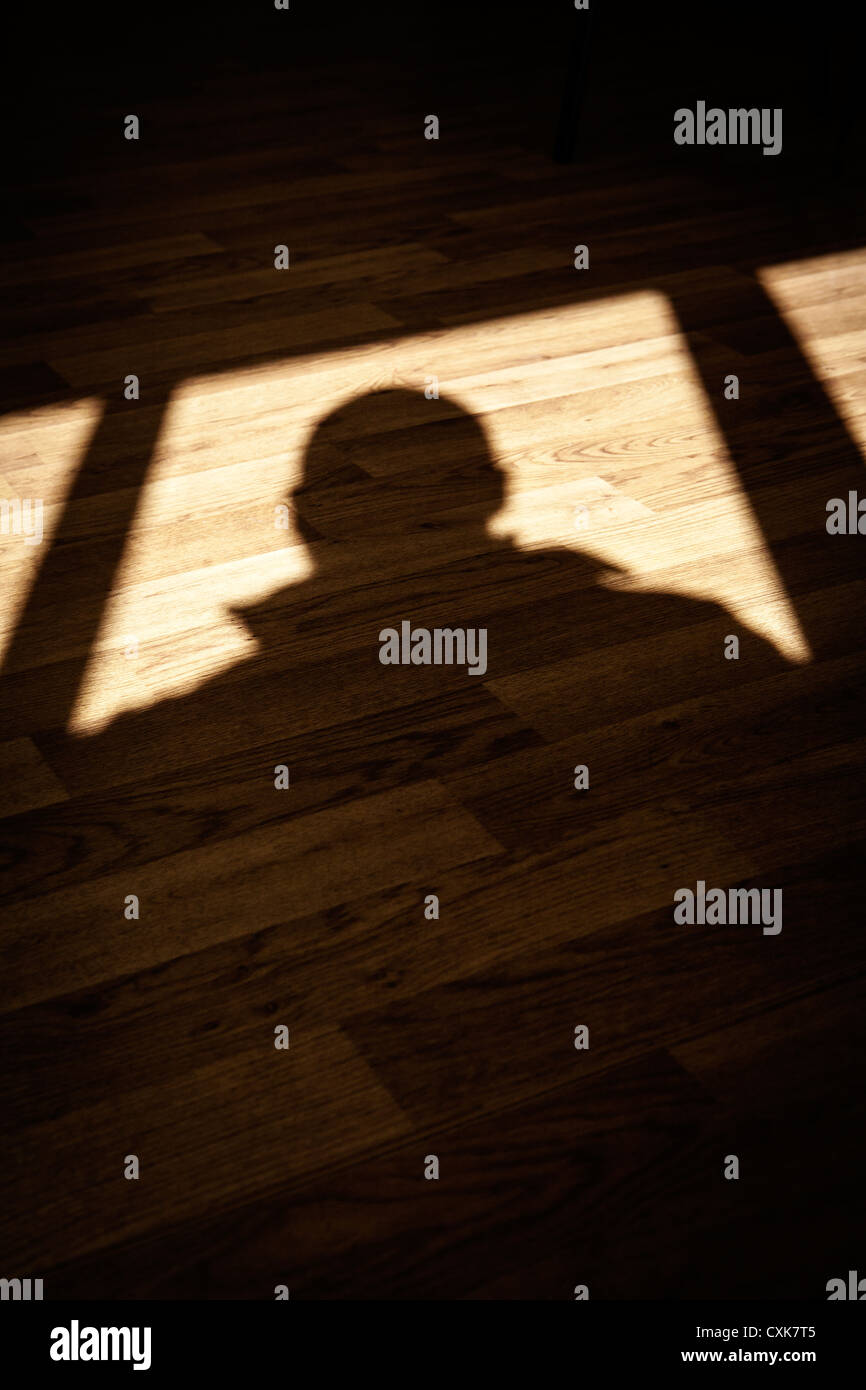 Schatten eines Mannes auf einem Holzfußboden Stockfoto