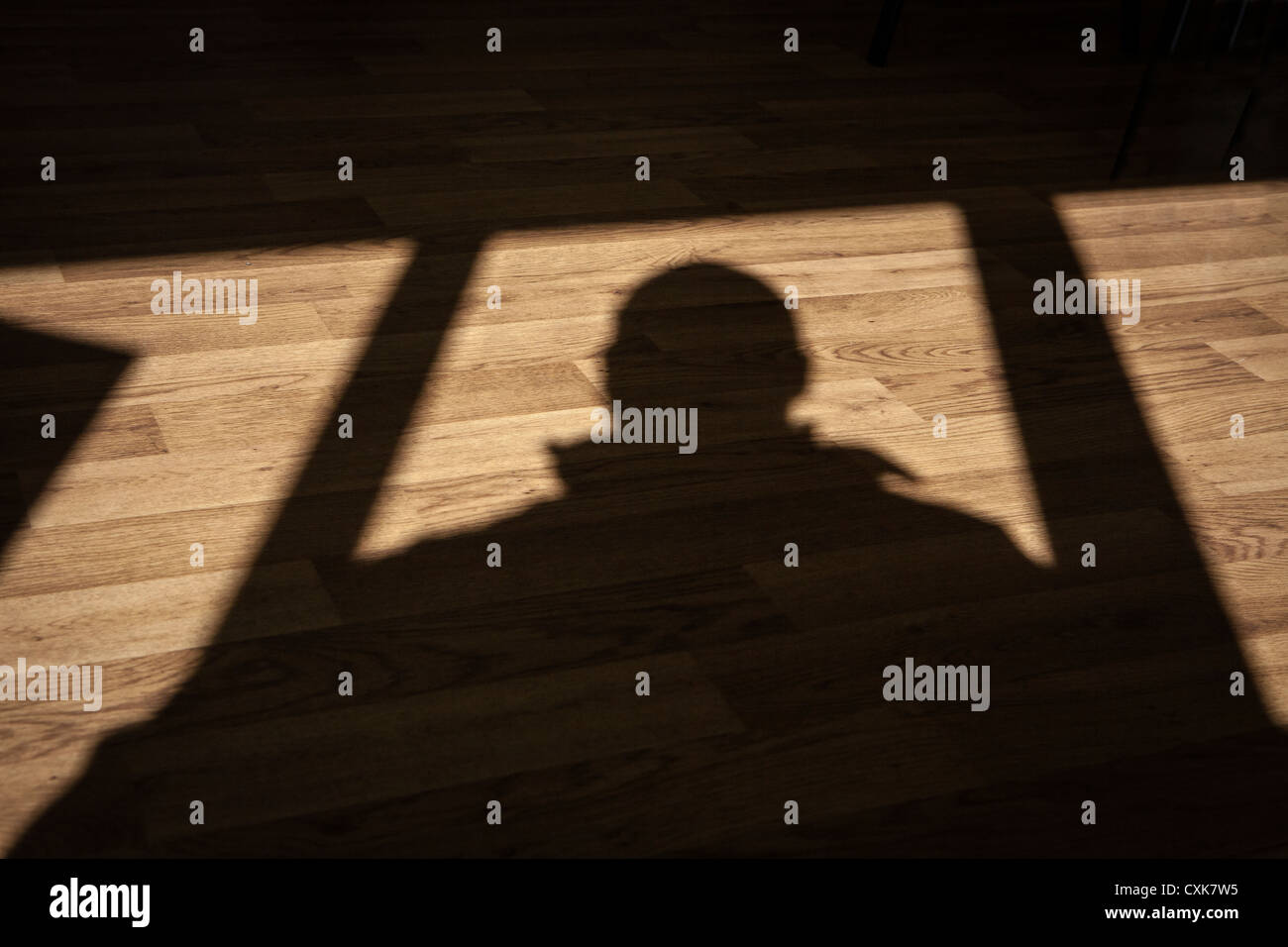 Schatten eines Mannes auf einem Holzfußboden Stockfoto