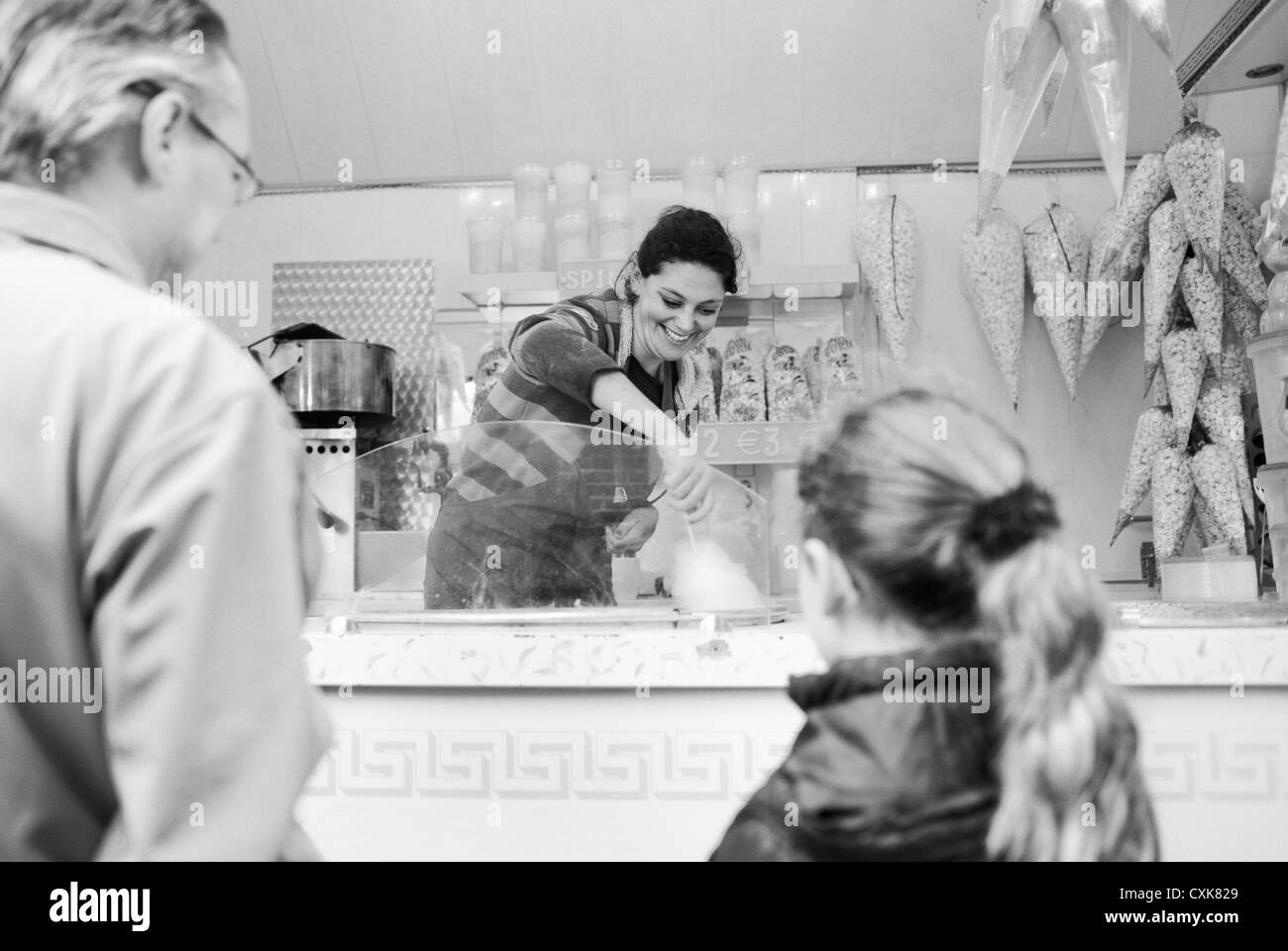 Frau macht eine Zuckerwatte für kleine Mädchen auf dem Jahrmarkt in der Stadt Leiden während der Party des Jahres; Drittel der Oktober Stockfoto