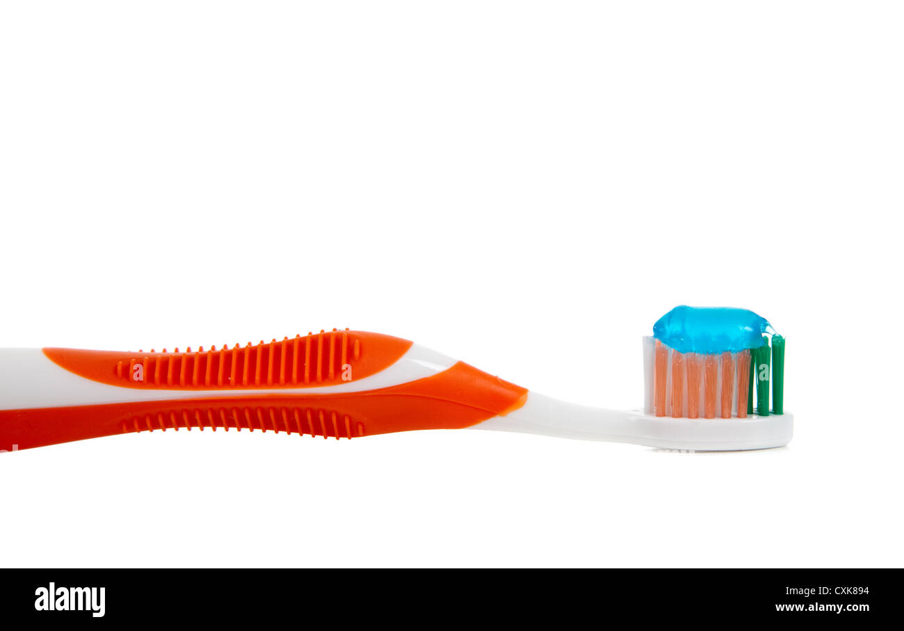 eine orange Zahnbürste und blauen Gel-Zahnpasta auf weißem Hintergrund Stockfoto