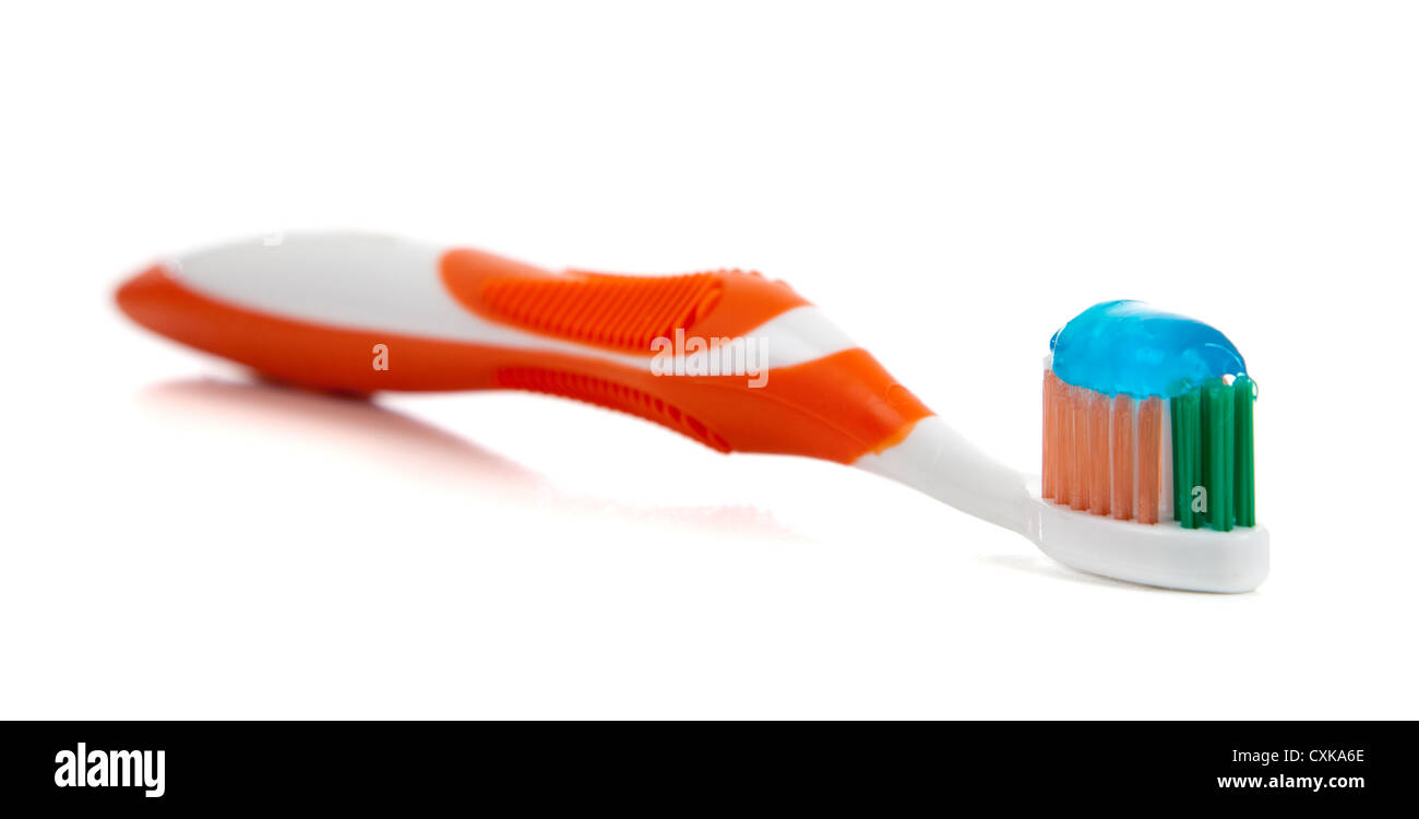 Orange Zahnbürste mit Zahnpasta auf einem weißen Hintergrund Stockfoto