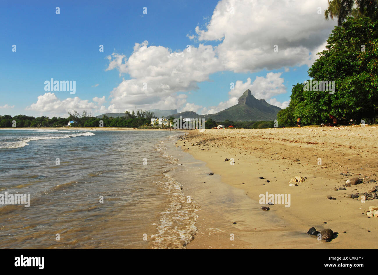 Mauritius, Tamarin, Blick auf ruhiger Strand mit Bäumen und Berggipfel im Hintergrund gegen bewölktem Himmel Stockfoto