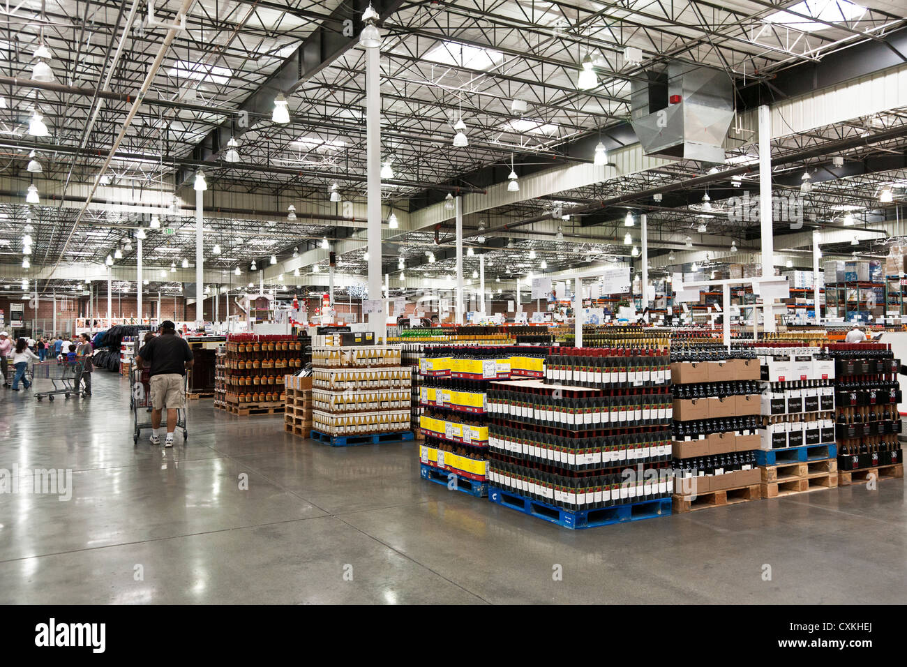 Kunden Mitglieder durchsuchen breite Gänge Schnaps Bereichs im riesigen Innenraum von Costco-große Box-Lager-Kette-Händler USA Stockfoto