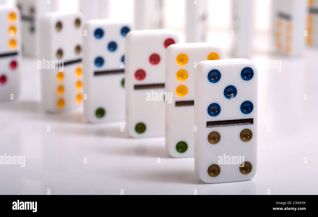 Eine Reihe von Dominosteinen stehen auf einem weißen Hintergrund Stockfoto