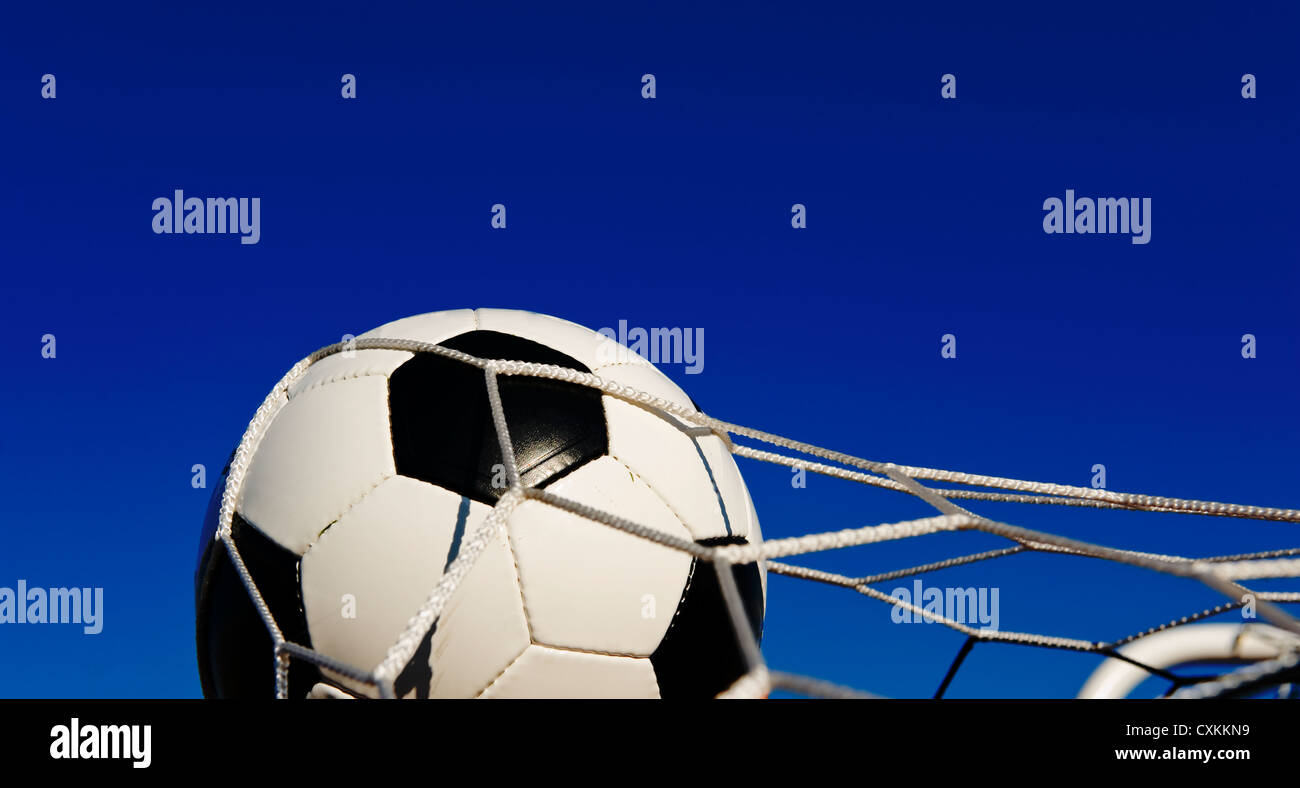 Eine traditionelle Fußball oder Fußball in ein Ziel netto vor einem blauen Himmel Stockfoto