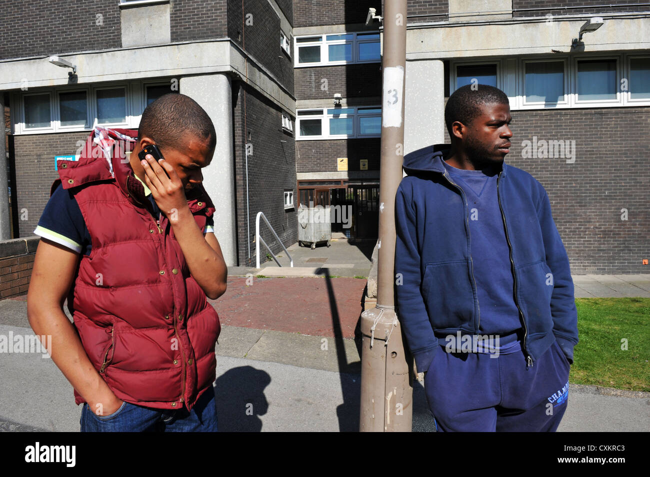 Zwei junge Arbeitslose Jugend Leeds UK, einer am Telefon sprechen. Stockfoto
