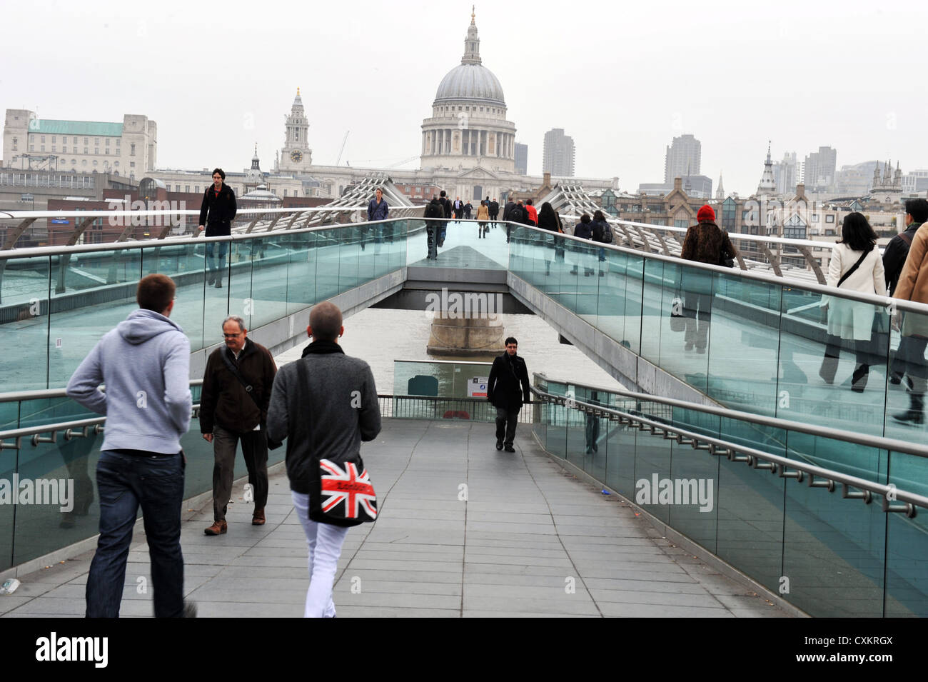 Pendler machen ihren Weg zur Arbeit auf Millennium Bridge, London, UK Stockfoto