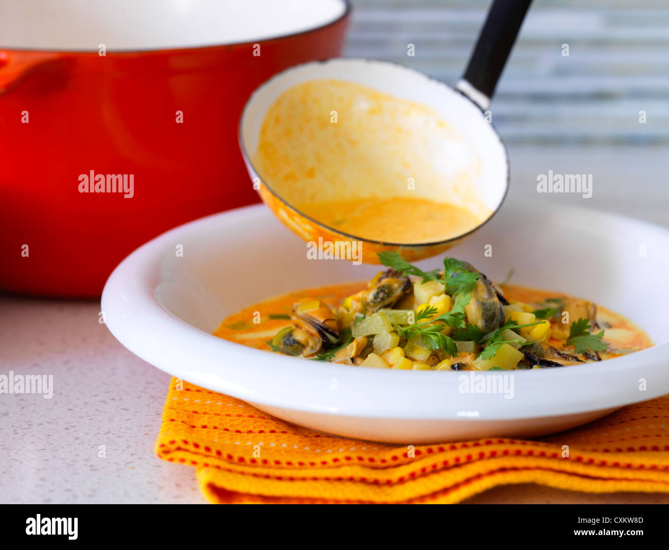 Miesmuschel-Suppe in Schüssel geschöpft wird Stockfoto