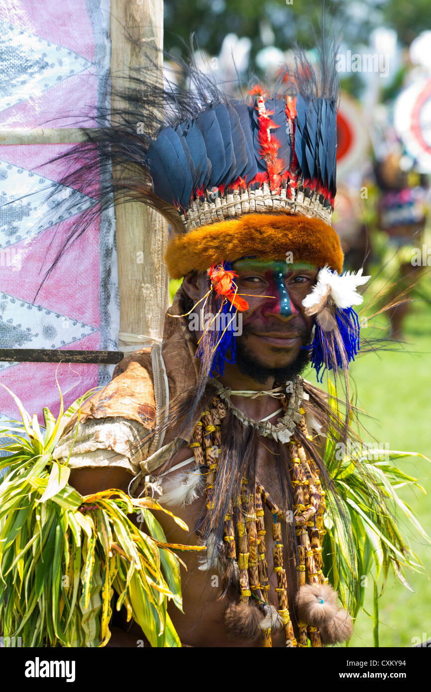 Porträt eines Mannes mit seinem Gesicht gemalt und Stammes-tragen Tracht bei Singsing Goroka Festival, Papua New Guinea Stockfoto