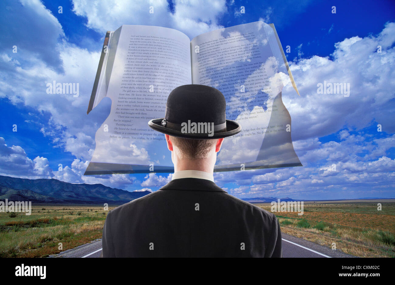 Magritte Mann mit Blick auf Buch in Wolken über einer kargen Wüste Autobahn Stockfoto