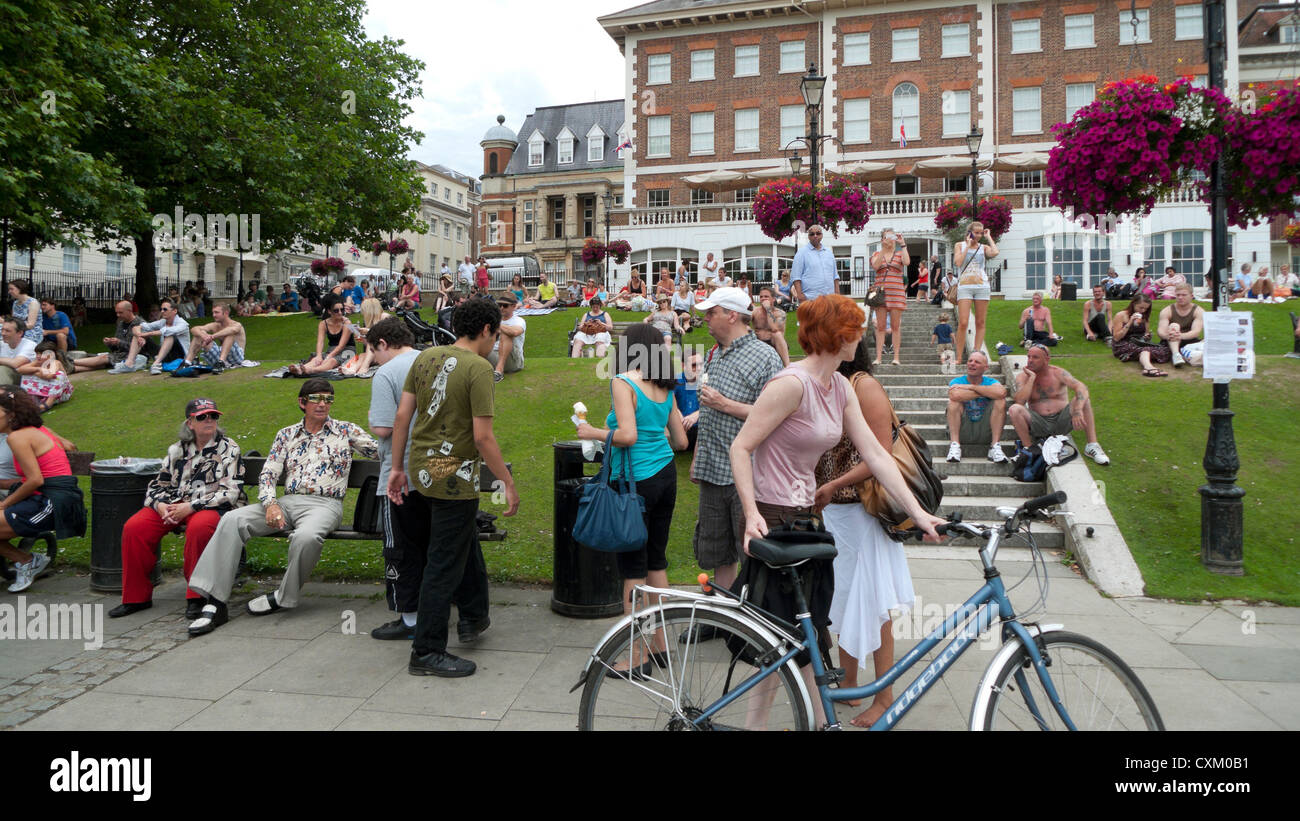 Menschen, die sich auf Bänken, Sitzterrassen und Fahrradfahrerin mit Fahrrad im Sommer entspannen Richmond upon Thames, London, England Großbritannien KATHY DEWITT Stockfoto