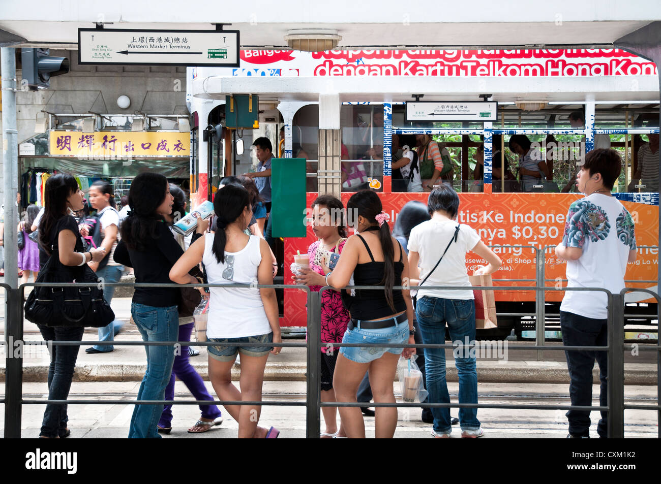 Die philippinischen Frauen an der Straßenbahnhaltestelle auf Des Voeux Road chatten, Sheung Wan Stockfoto