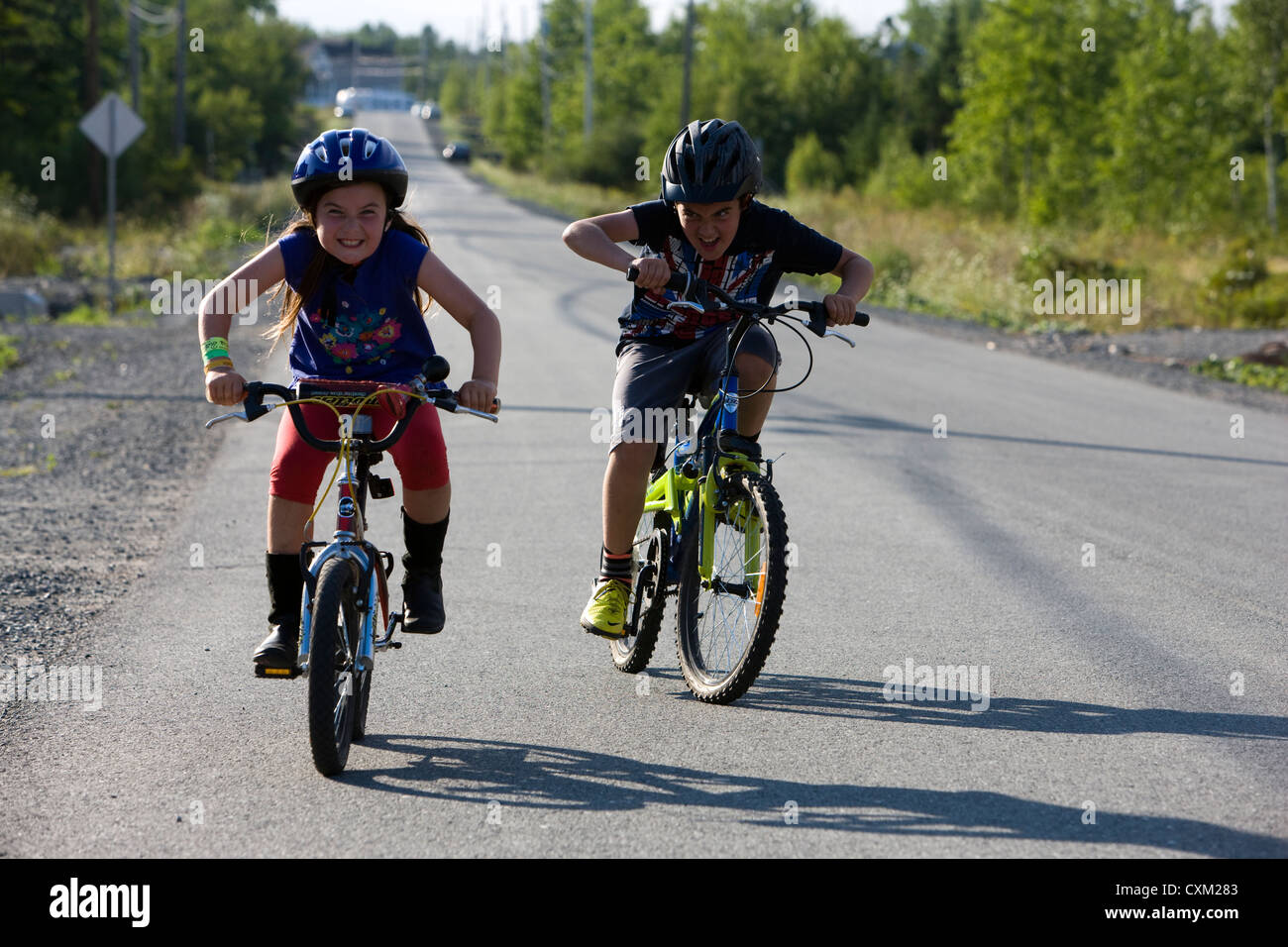 Kinder freuen sich über Fahrradfahren in kanadischen Wohnstraße Stockfoto
