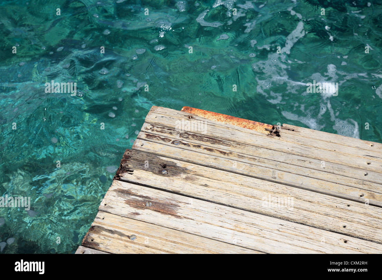 Holzplattform mit kristallklaren türkisblauen Meer in Kefalonia, Griechenland. Stockfoto