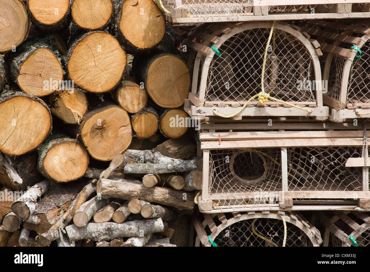 Brennholz-Protokolle und Hummer Töpfe gestapelt gegen eine Fischerhütte im Rustico, Prince Edward Island, Canada Stockfoto