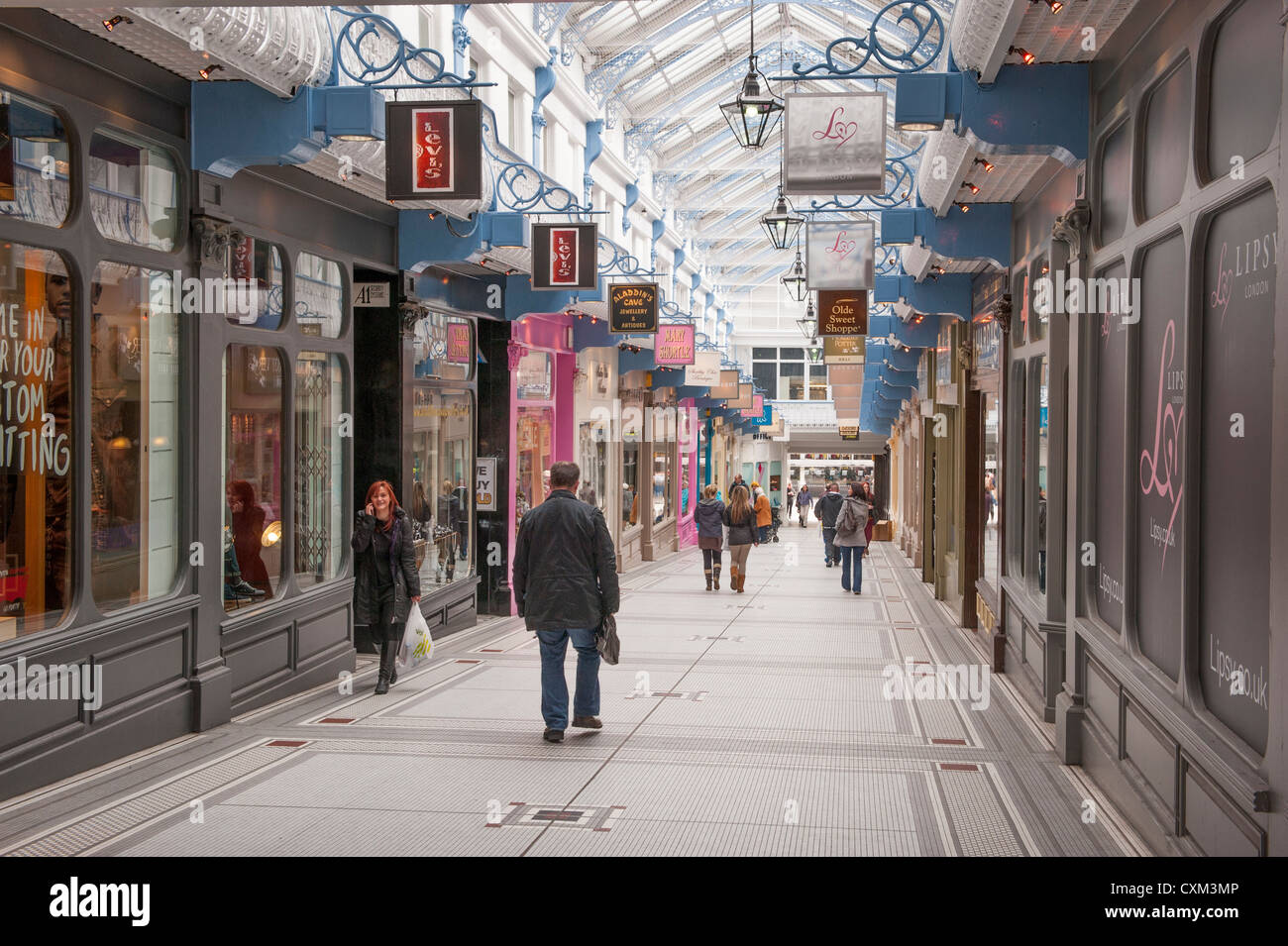 Käufer wandern in attraktiven historischen Königin Arcade (Zeilen von Geschäften unter beeindruckenden Glasdach) - Zentrum der Stadt Leeds, West Yorkshire, England, UK. Stockfoto