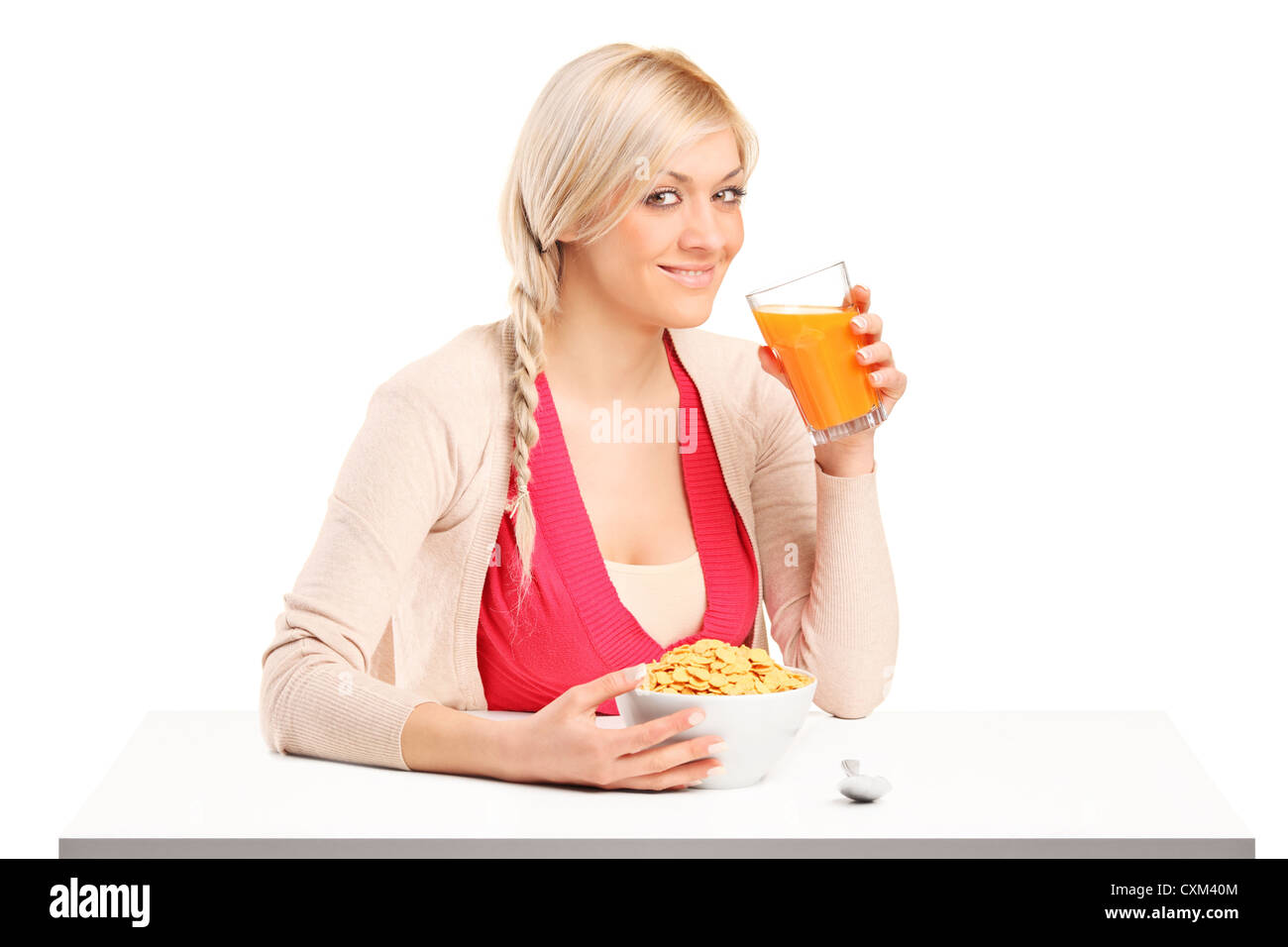 Eine junge Frau einen Saft zu trinken und Essen Cornflakes zum Frühstück isoliert auf weißem Hintergrund Stockfoto