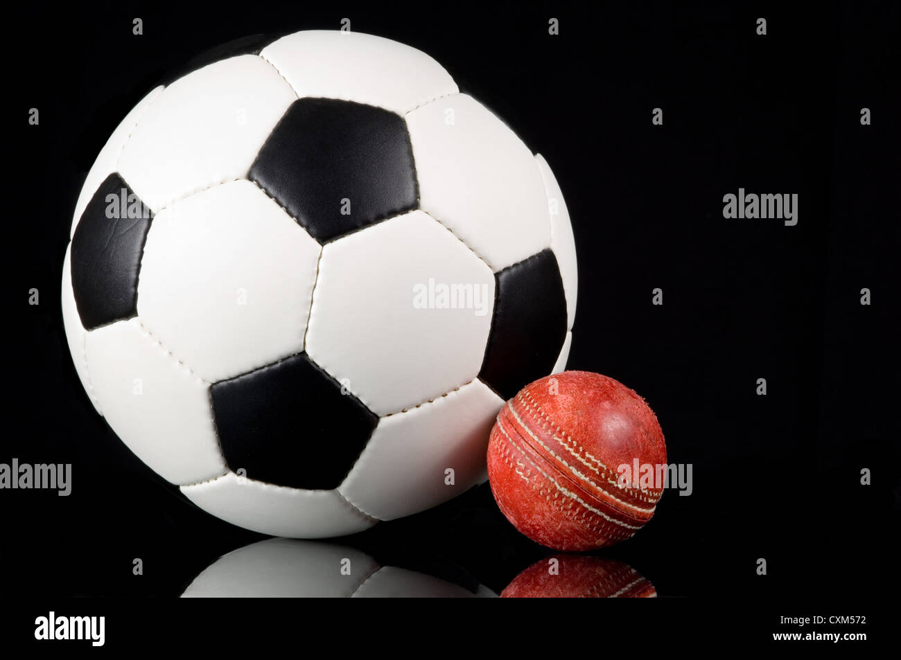 Fußball und Kricket Kugel auf einem schwarzen Hintergrund Stockfoto