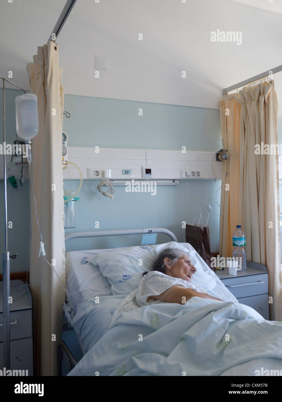 Ältere Frau liegt auf ihrem Bett in einer Krankenstation Stockfoto