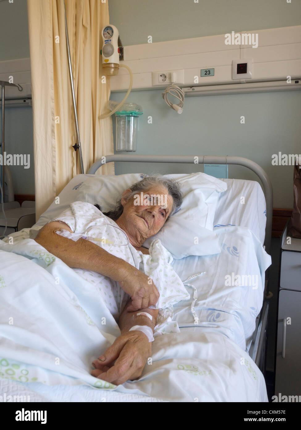 Ältere Frau liegt auf ihrem Bett in einer Krankenstation Stockfoto