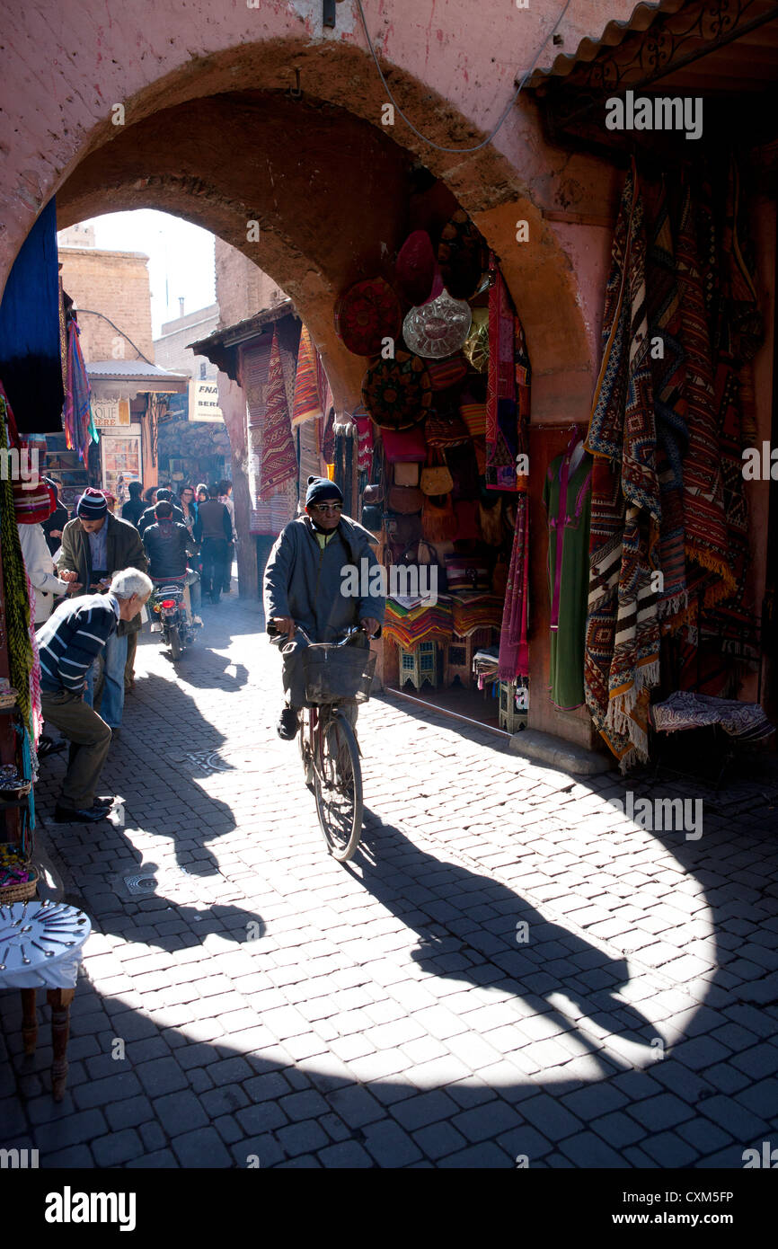 Marokkanischen Mann auf dem Fahrrad mit Bogen und Geschäften, Marrakesch, Marokko Stockfoto