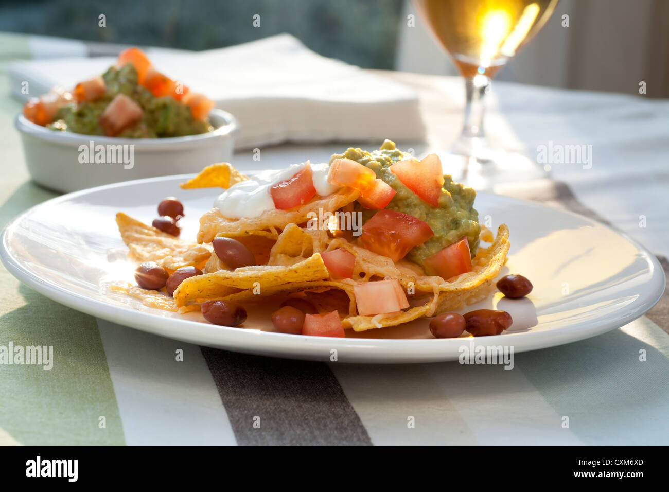 Frische Nacho-Chips mit Bohnen, Tomaten, Käse und guacamole Stockfoto