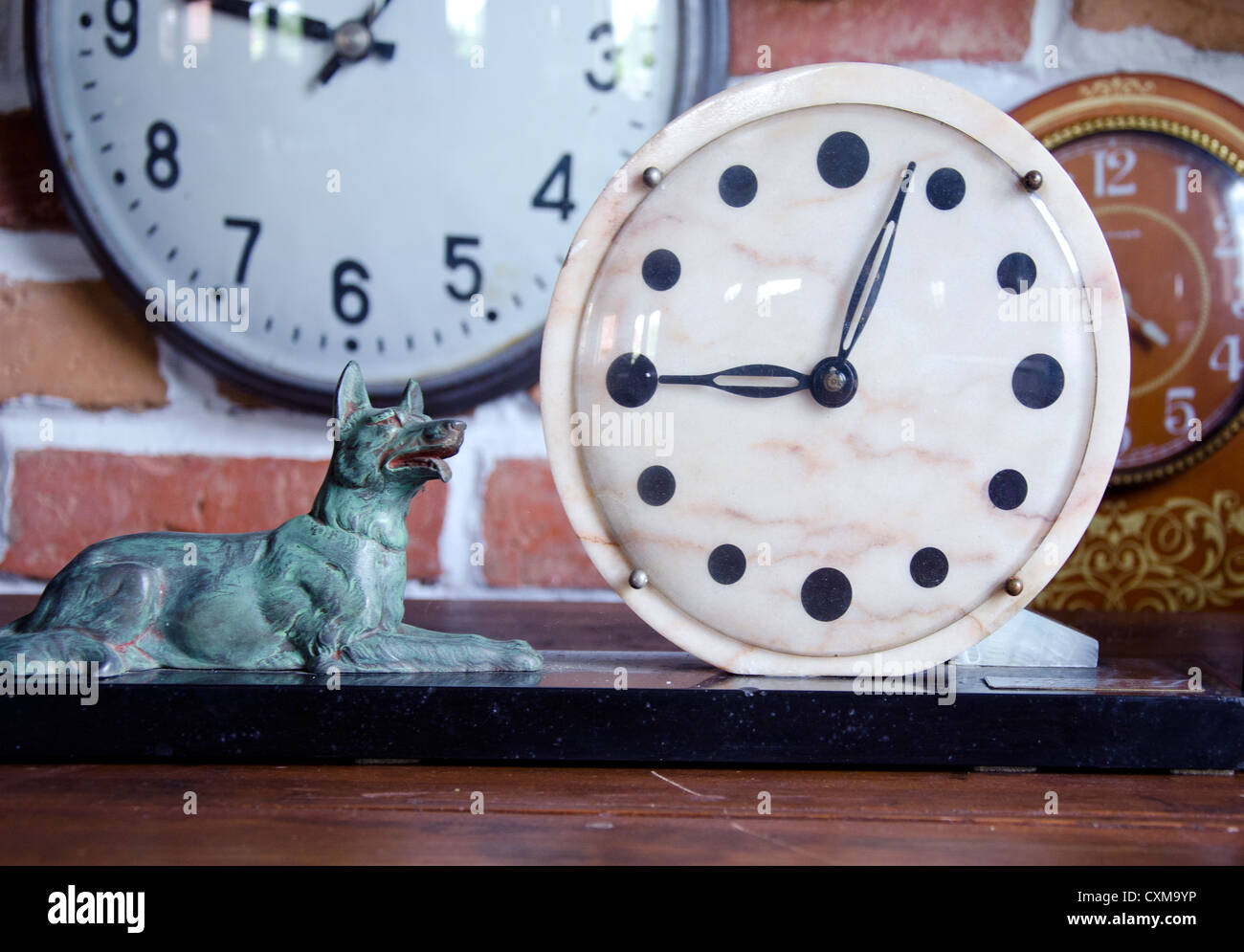alte Uhr Stein Zifferblatt mit Messing-Hund-Skulptur Stockfoto