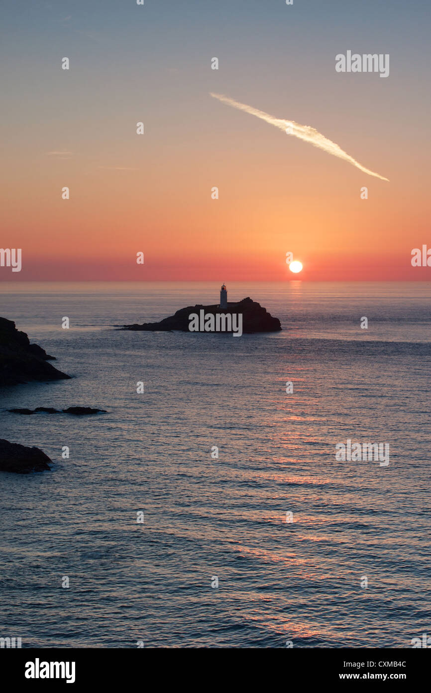 Die untergehende Sonne hinter Godrevy Leuchtturm in Cornwall Stockfoto