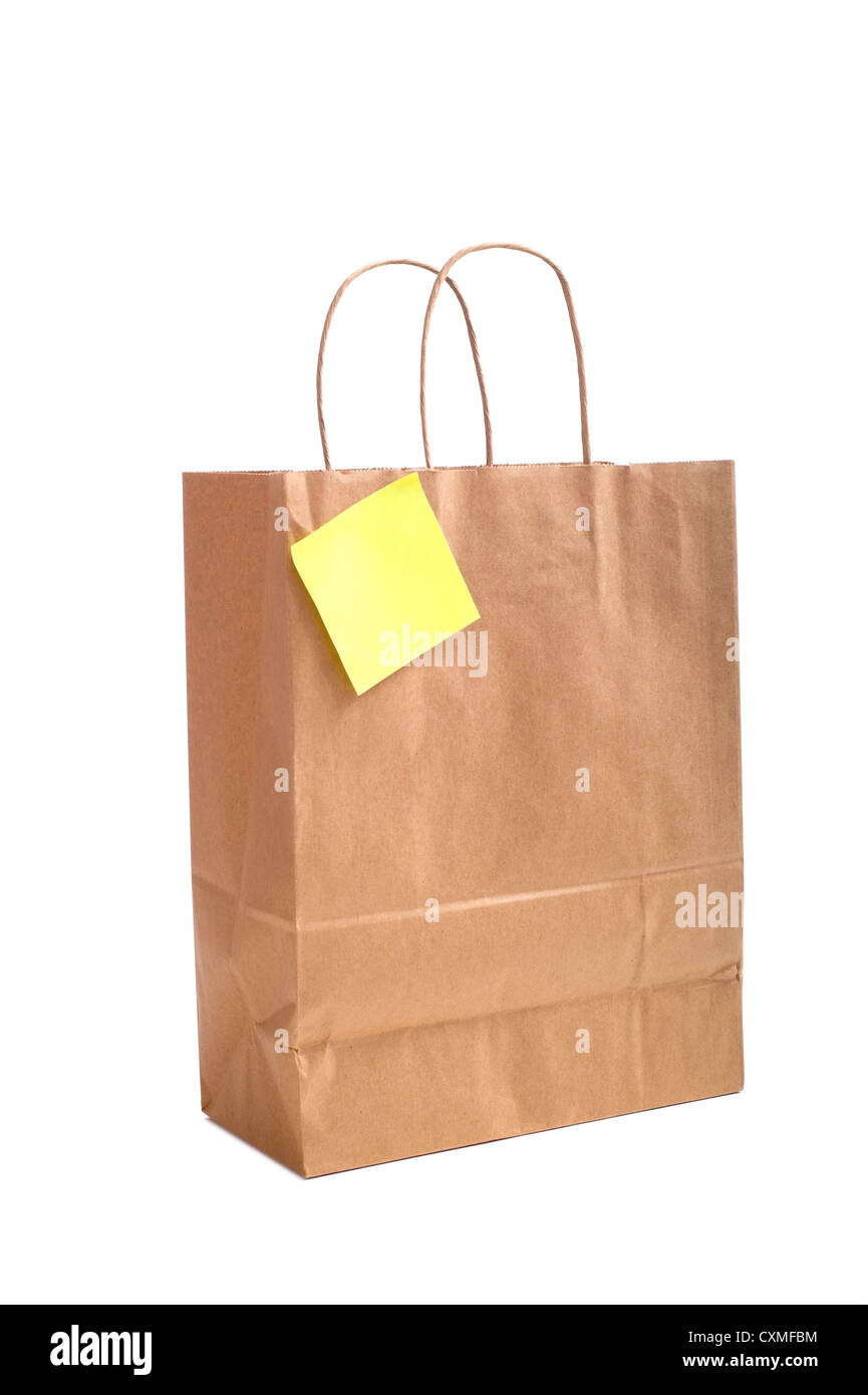 Eine braune Einkaufstasche mit Griffe mit einem Notizzettel oder Notiz beigefügt auf weißem Hintergrund Stockfoto