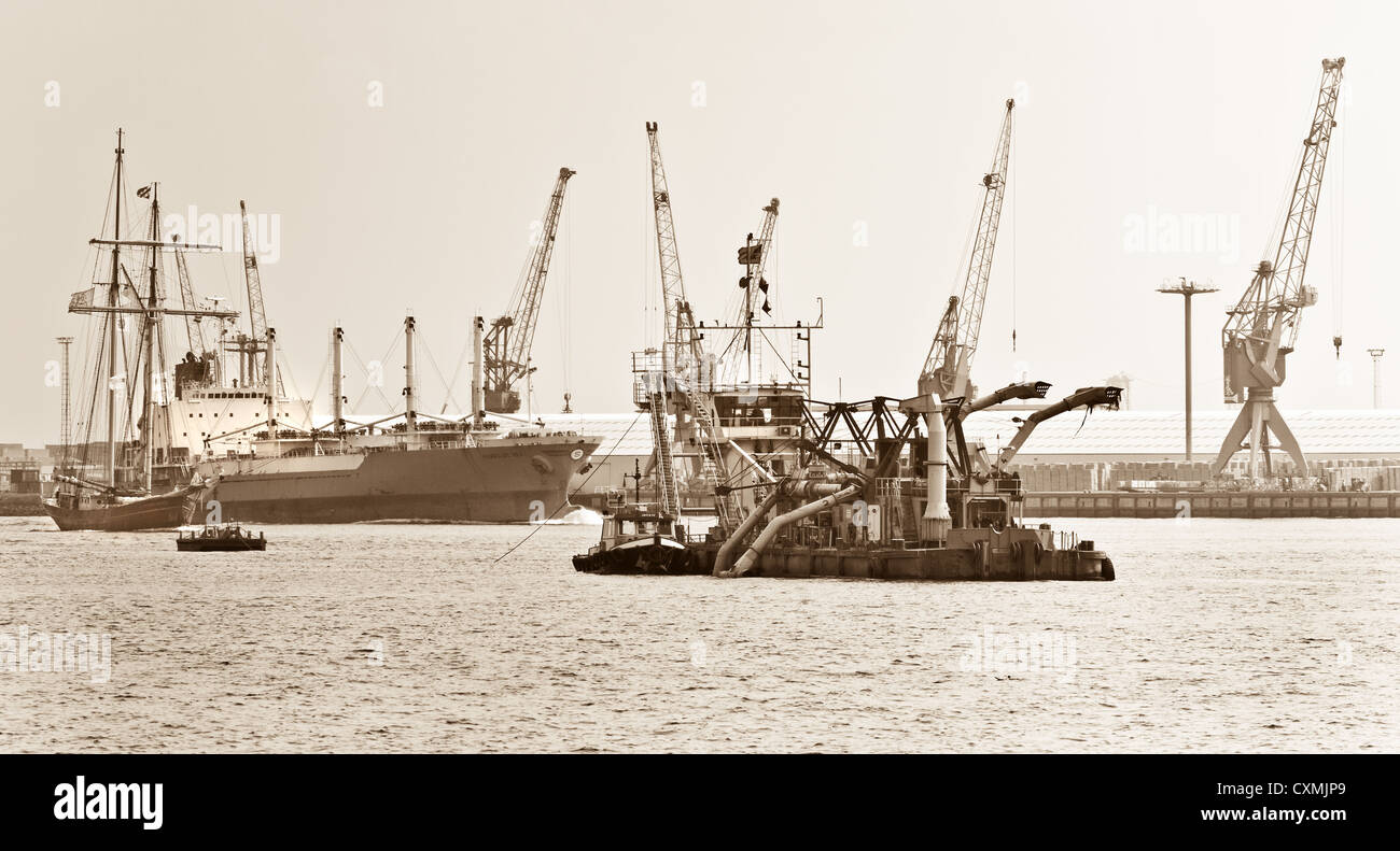 Gebucht am Fluss mit Schiffen und Industrietätigkeit - Sepia Farbe Stockfoto