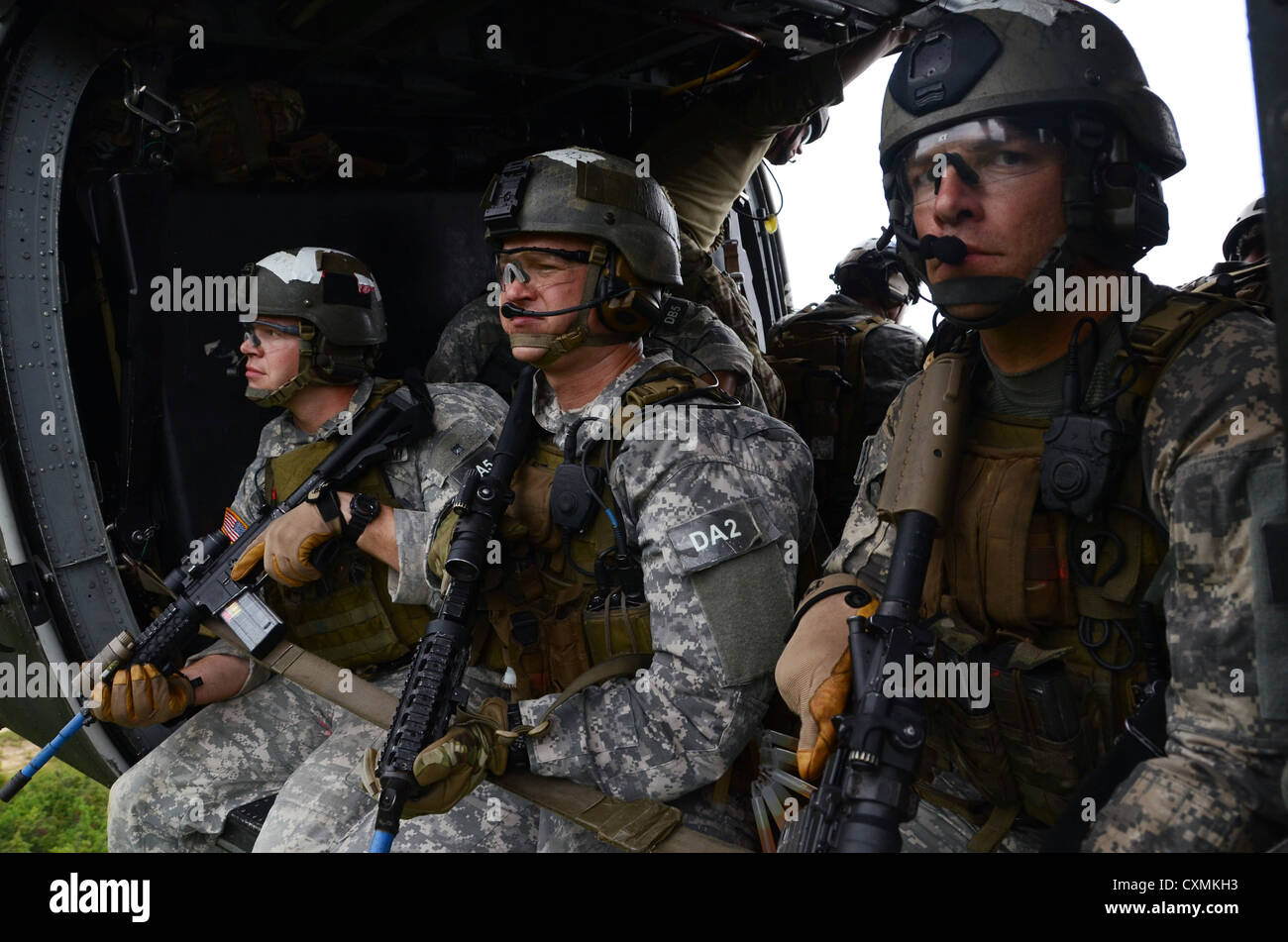 U.S. Army Special Forces Suche nach Bedrohungen während der Fahrt in einem MH-60 Black Hawk nach schnellen Abseilen auf ein Ziel während des Trainings August 2012 an der John F. Kennedy Special Warfare Center and School in Fort Bragg, North Carolina. Stockfoto