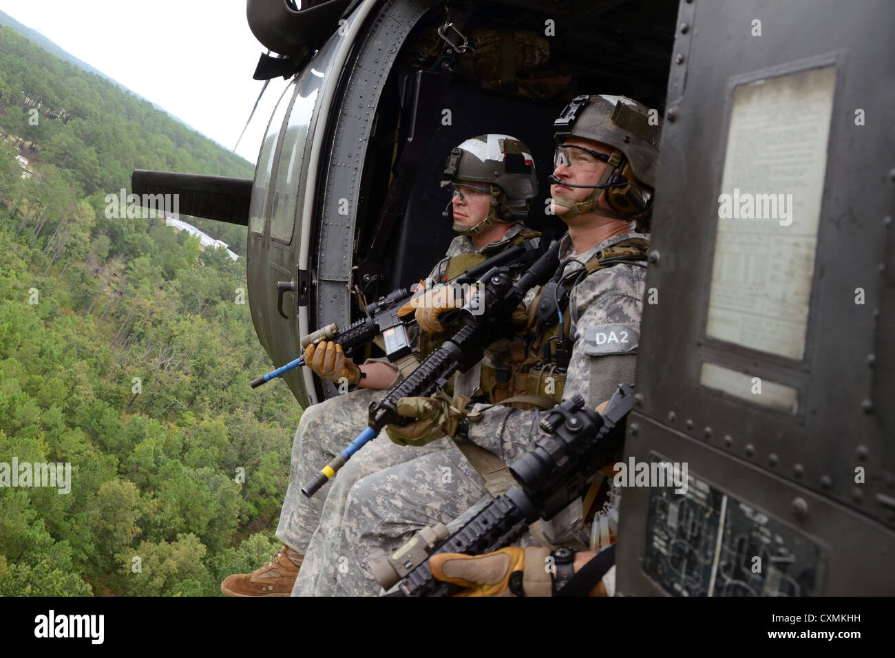 U.S. Army Special Forces Suche nach Bedrohungen während der Fahrt in einem MH-60 Black Hawk nach schnellen Abseilen auf ein Ziel während des Trainings August 2012 an der John F. Kennedy Special Warfare Center and School in Fort Bragg, North Carolina. Stockfoto