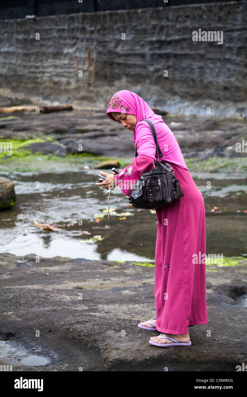 Frau am Strand von der Tempel Pura Tanahlot auf Bali Stockfoto