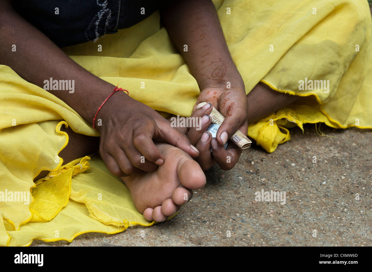 Indische Straße Mädchen um Geld betteln mit rupee Münzen in der Hand. Andhra Pradesh, Indien Stockfoto