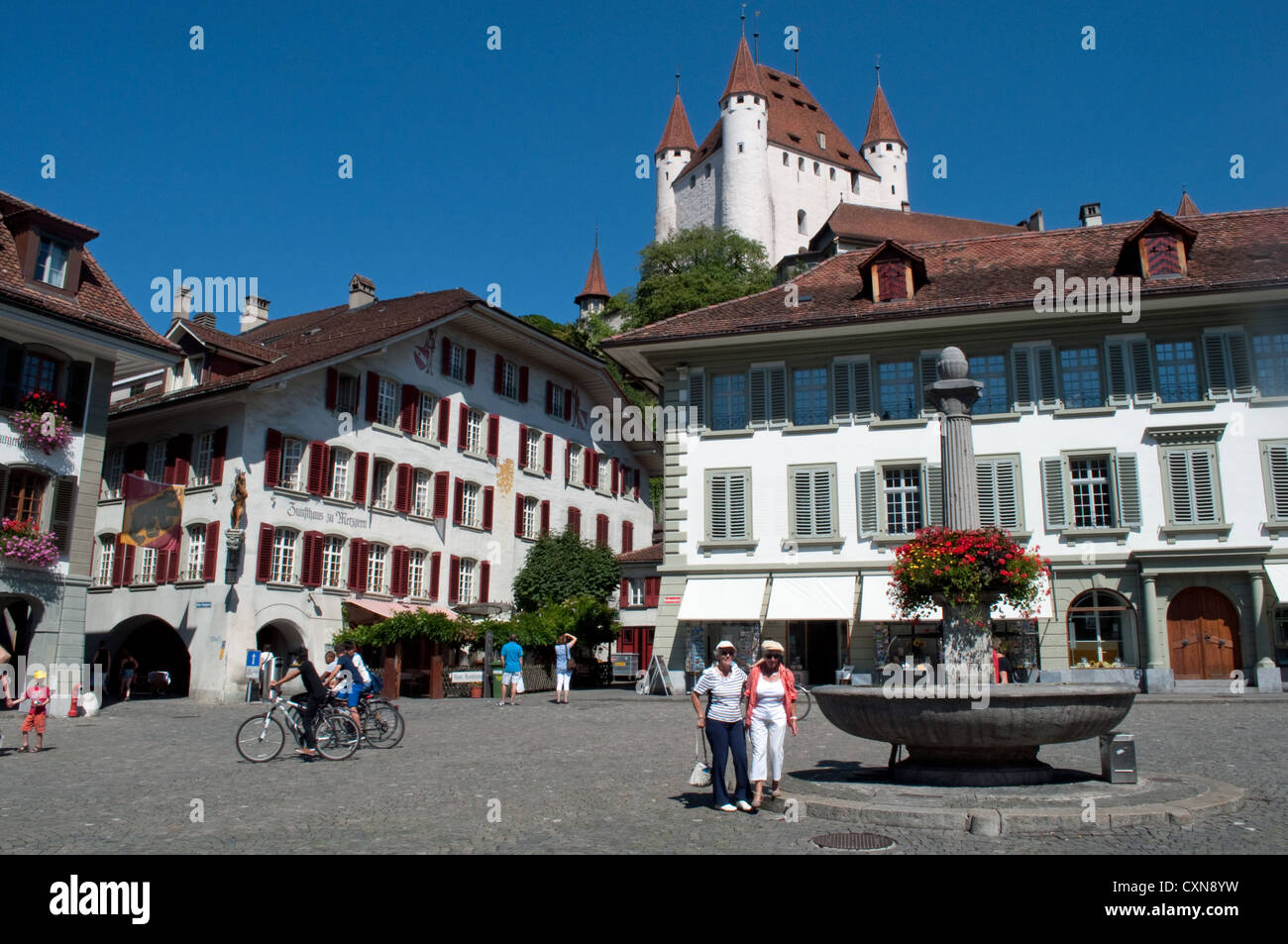 Radfahrer und Touristen Rathausplatz mit Thun Schloss alte Stadt Thun Kanton Bern Schweiz Stockfoto