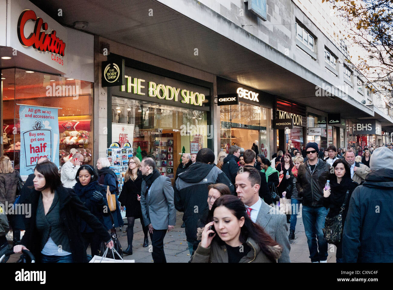 Weihnachts-Einkäufer in der Oxford Street, London, Anzeige Clinton Cards, Body Shop, Geox, Monsun Stockfoto