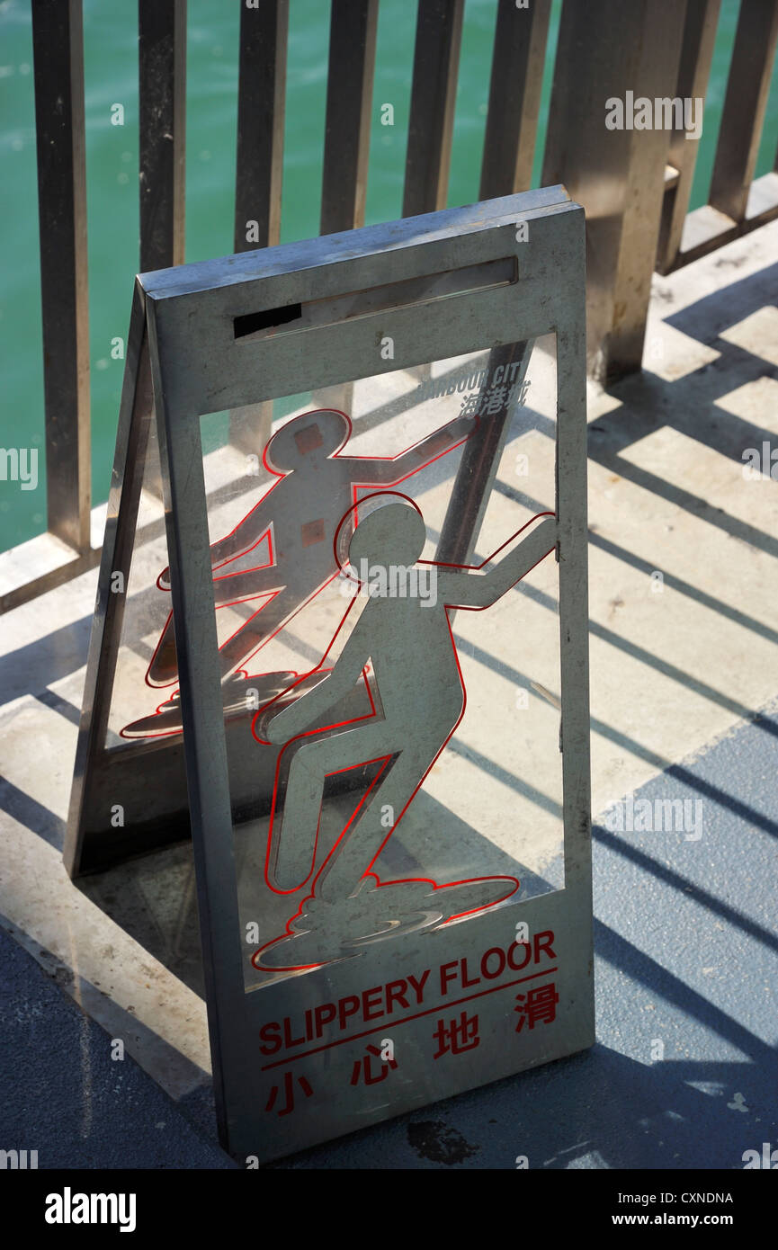 Rutschiger Boden Warnschild am Star Ferry Pier, Hongkong CN Stockfoto