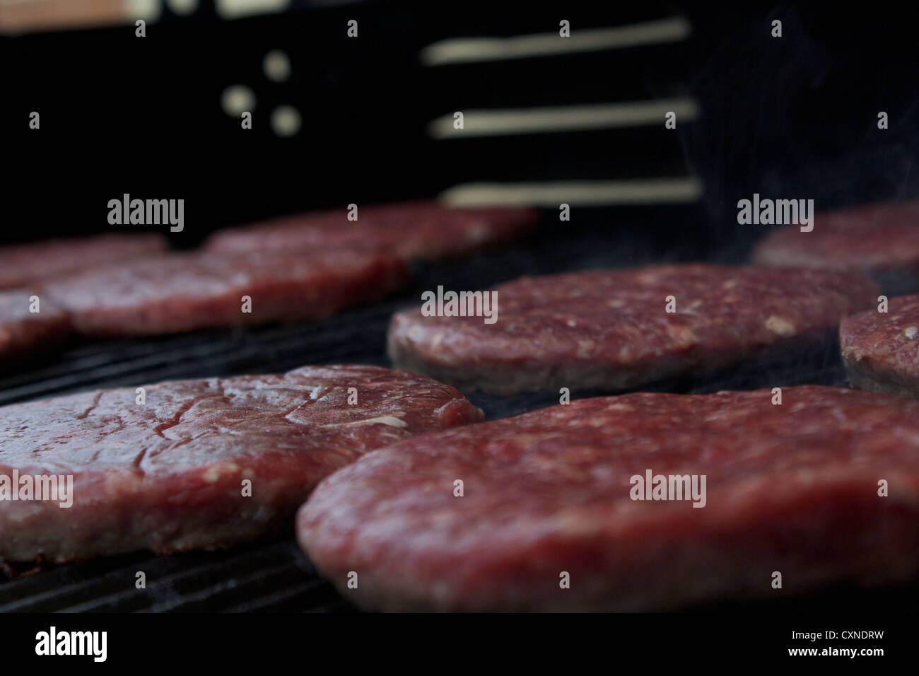 Dies ist ein Bild von 100 % Bio-Rindfleisch-Burger auf einem Grill Stockfoto