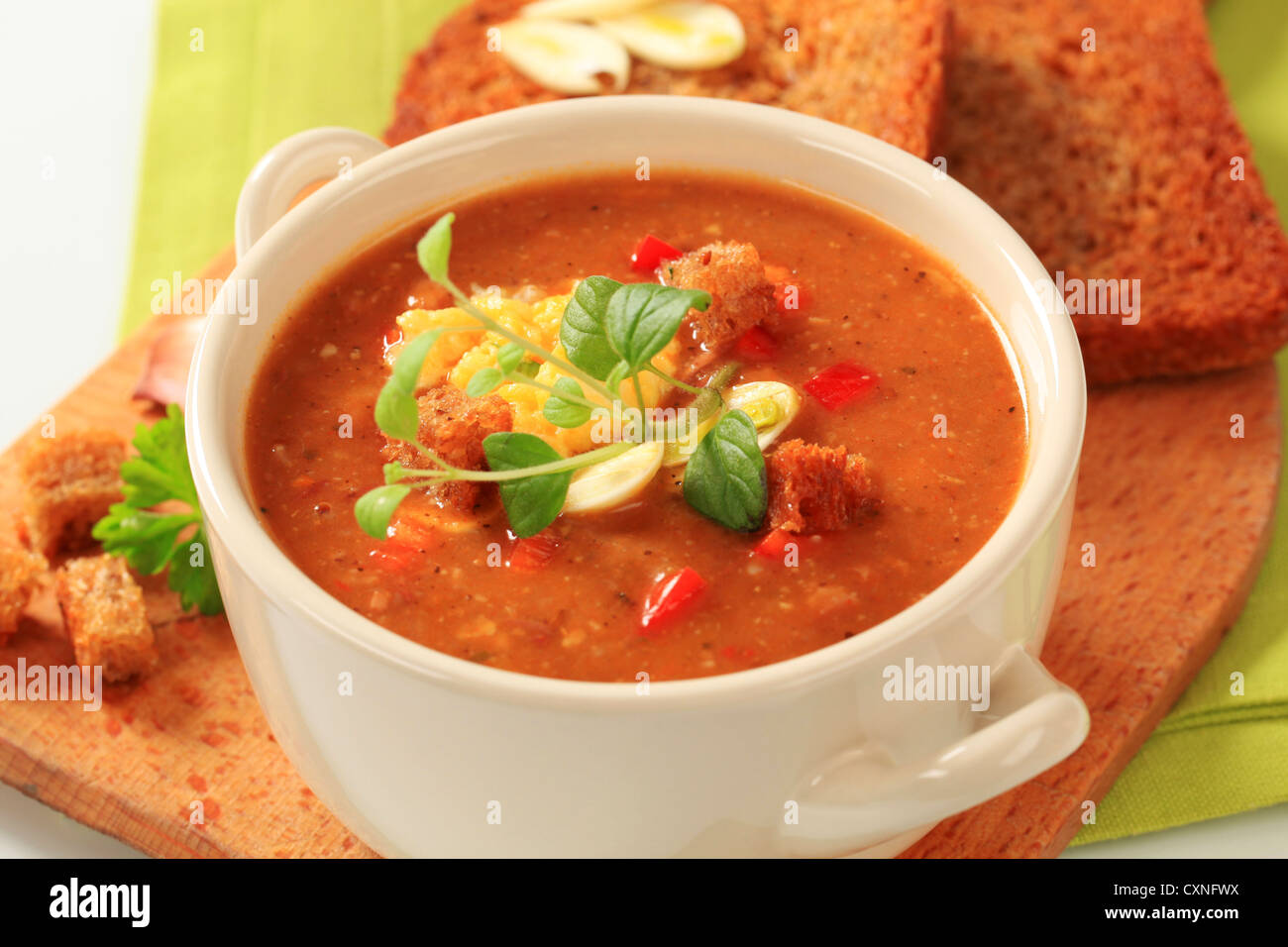 Tasse würzige Suppe mit geröstetem Brot Stockfoto