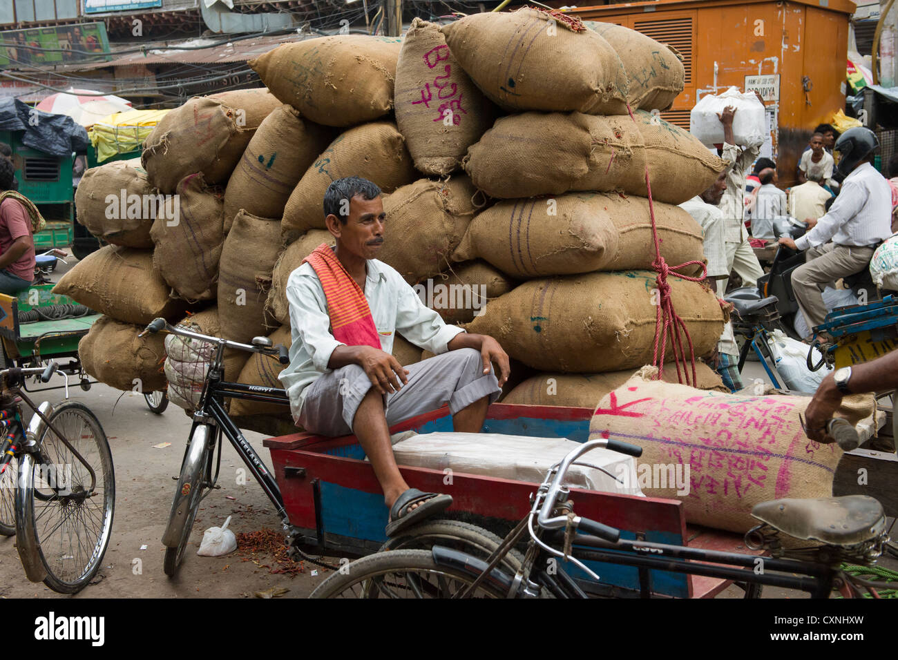 Cyclecart Fahrer vor einen Wagen beladen mit Sackleinen Säcke Khari Baoli unterwegs, (Markt Gewürzbasar aus Chandni Chowk), Alt-Delhi, Indien Stockfoto