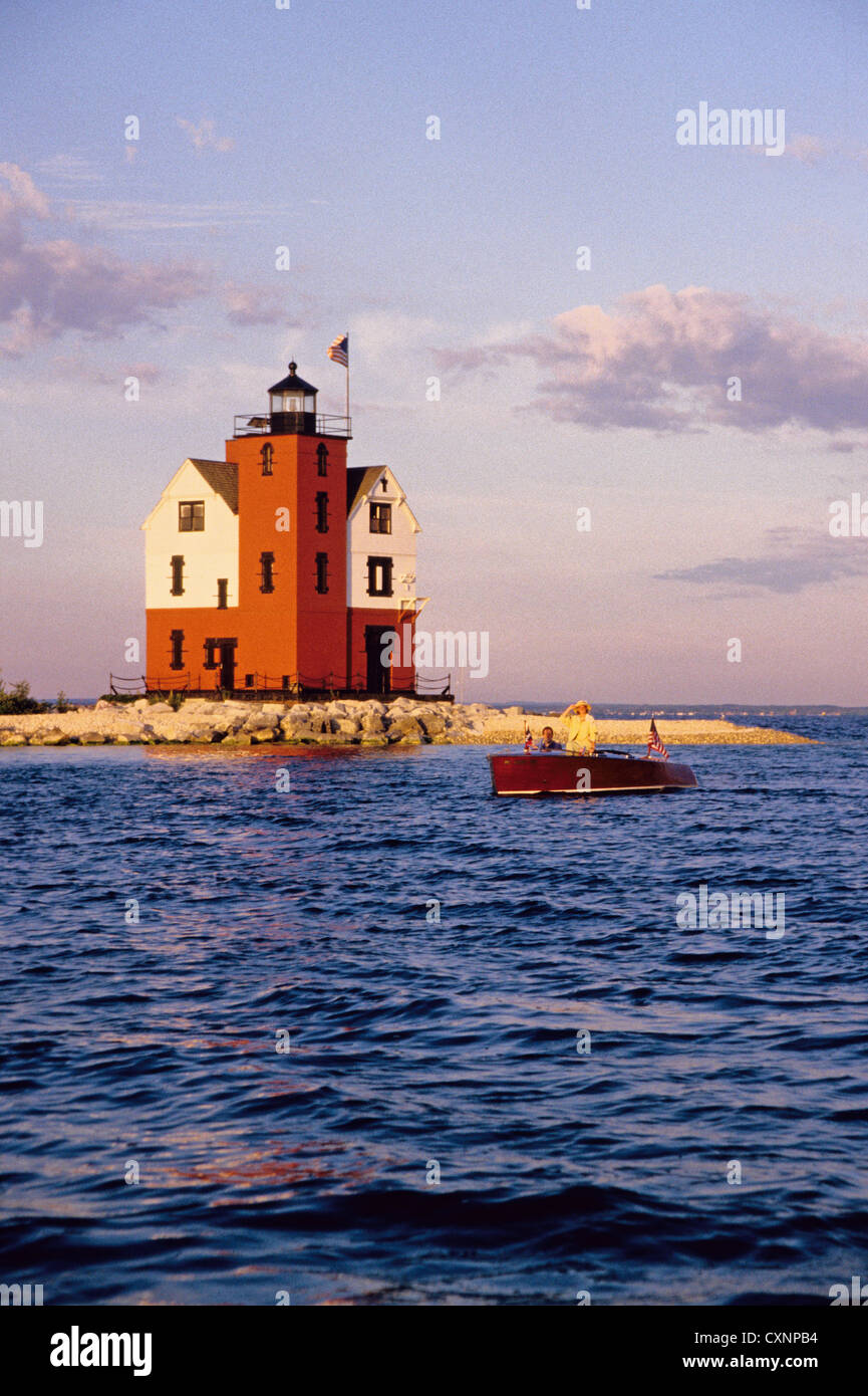 Runde Insel-Leuchtturm mit Holzboot in Straits of Mackinac in der Nähe von Mackinac Island, Michigan, USA Stockfoto