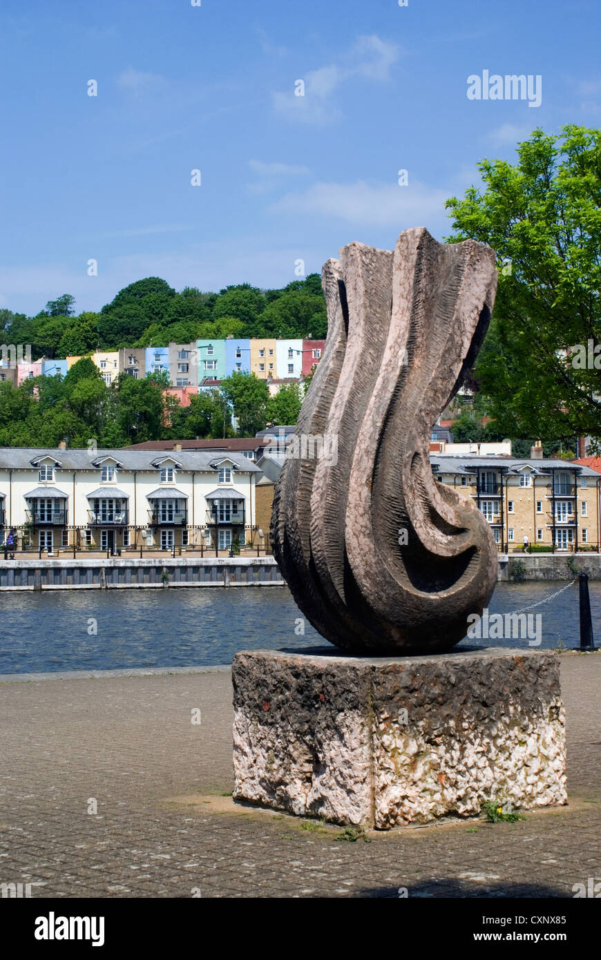 Skulptur neben Floating Harbour, Bristol mit den bunten Häusern von Hotwells in der Ferne. Stockfoto