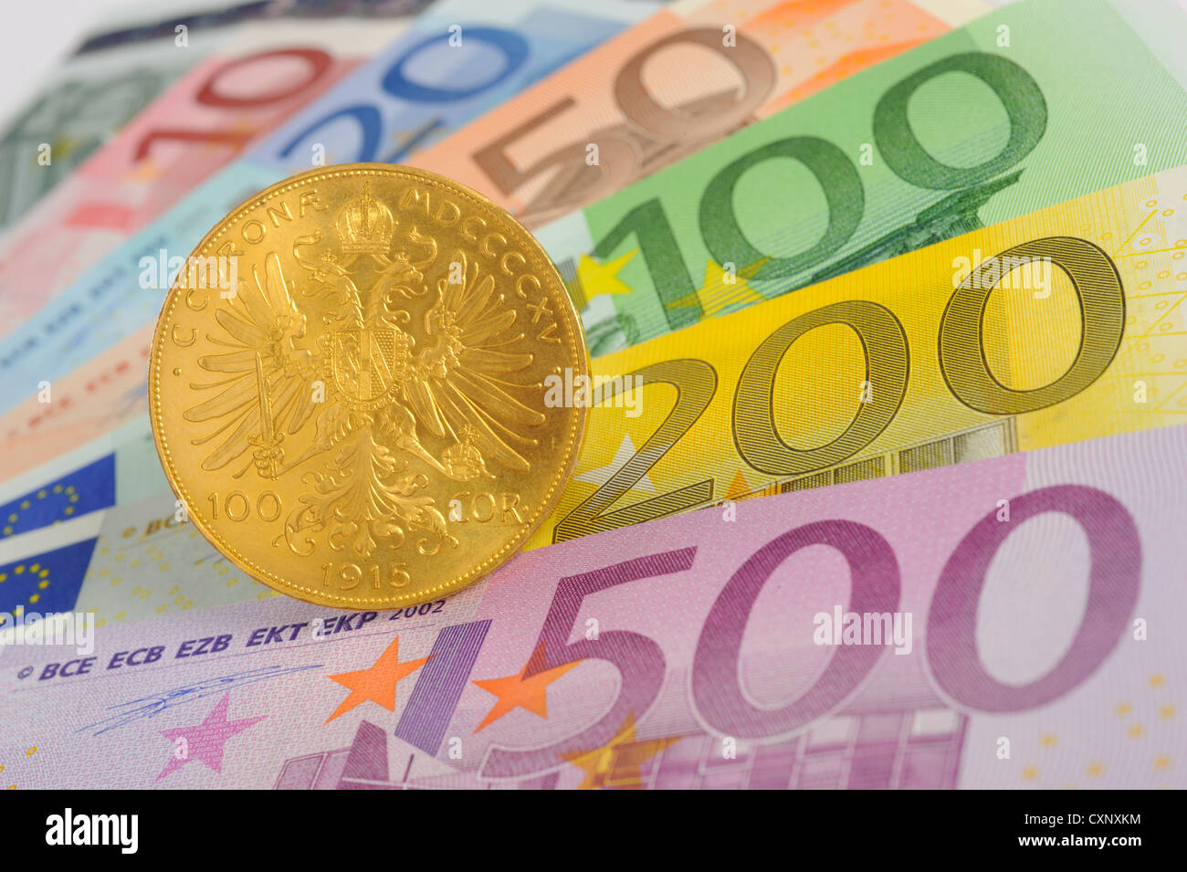 Fan von Euro-Banknoten mit Goldmünze Stockfoto