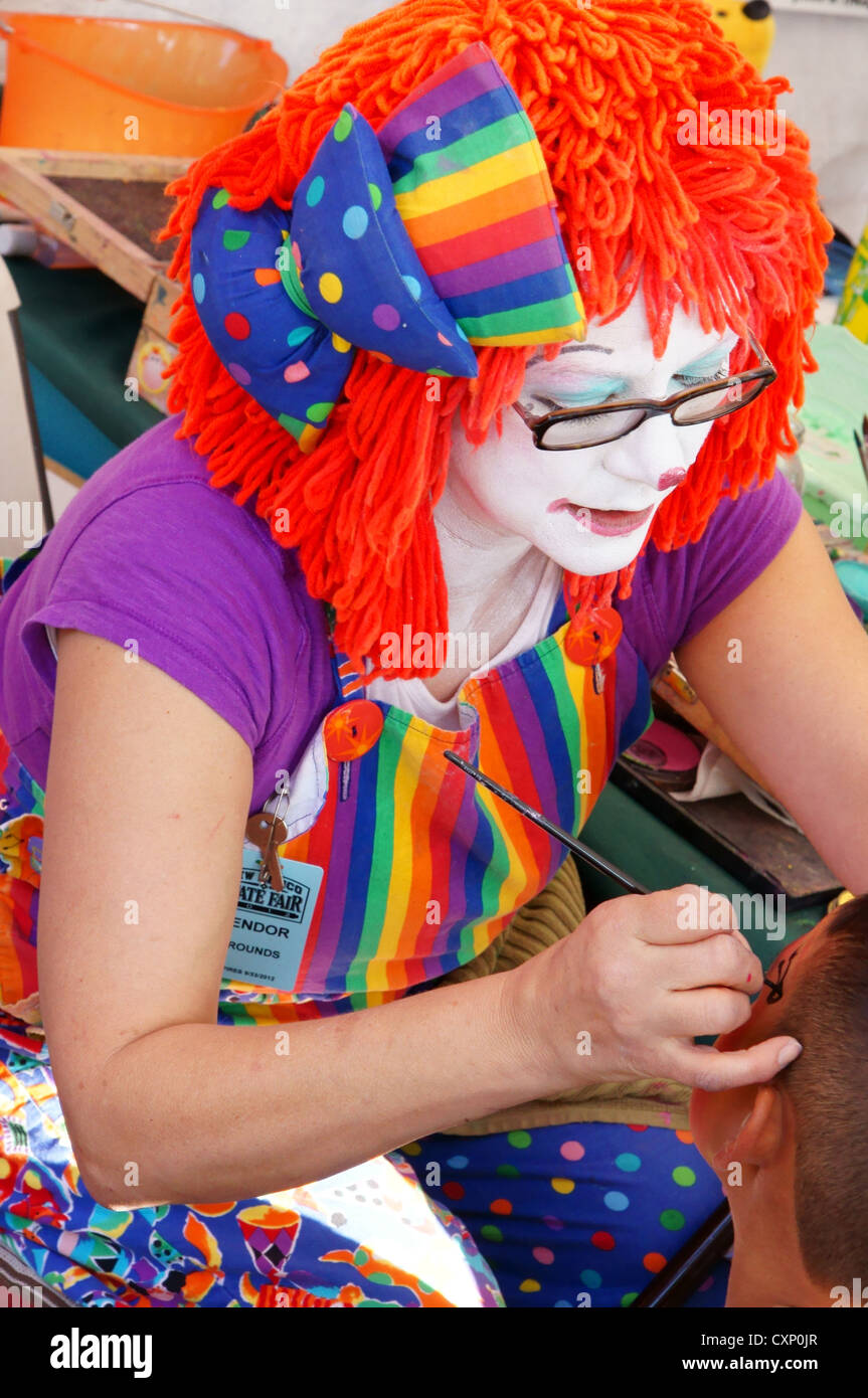 Clown Frau weibliche Teen Teenager tun, Kinderschminken, die New Mexico  State fair Midway Karneval carnivale Stockfotografie - Alamy