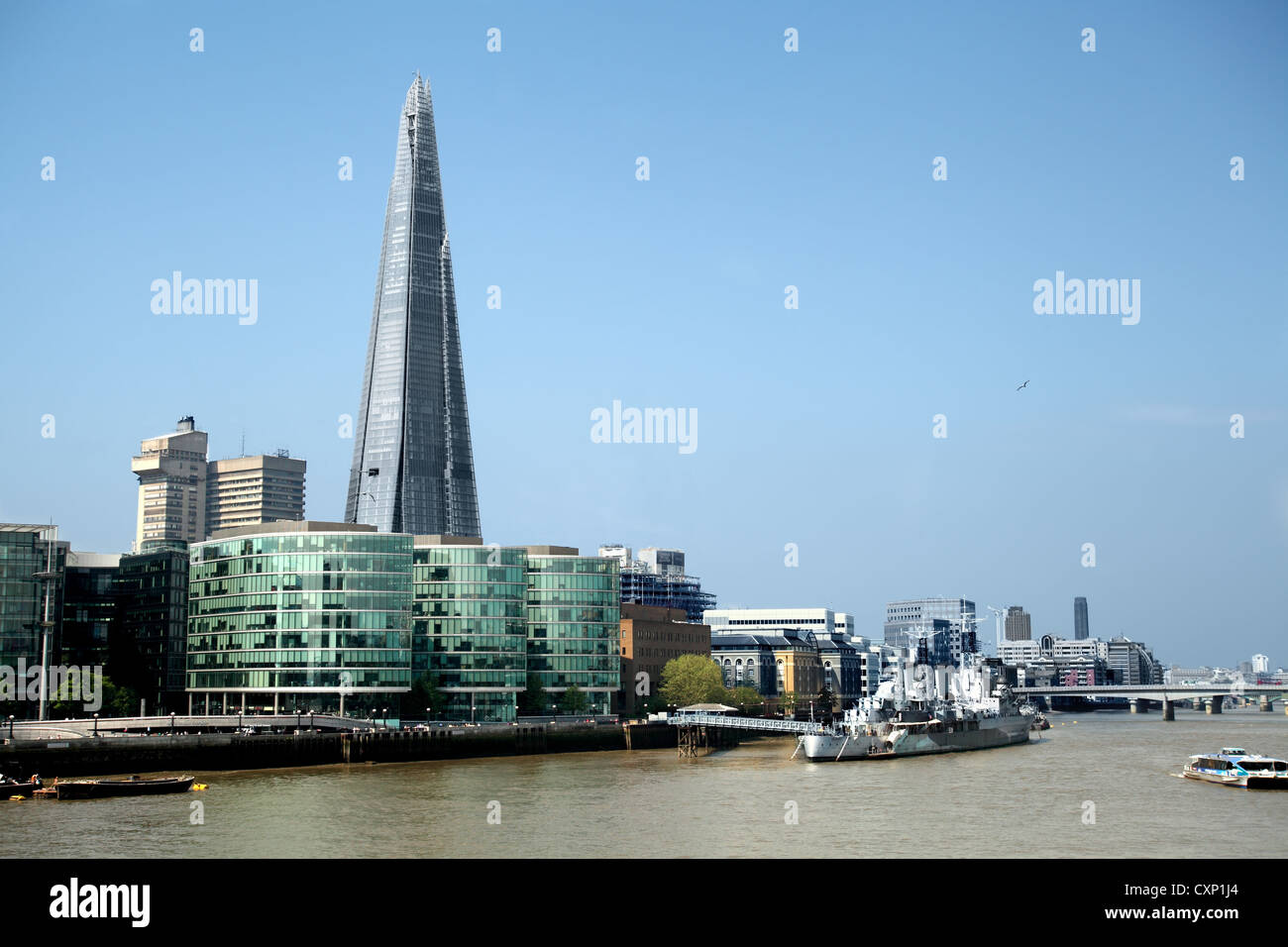 Ein Bild über den Fluss Themse in London, zeigt WW2-Schlachtschiff HMS Belfast im Vordergrund, jetzt ein schwimmendes Museum und die Scherbe im Hintergrund Stockfoto