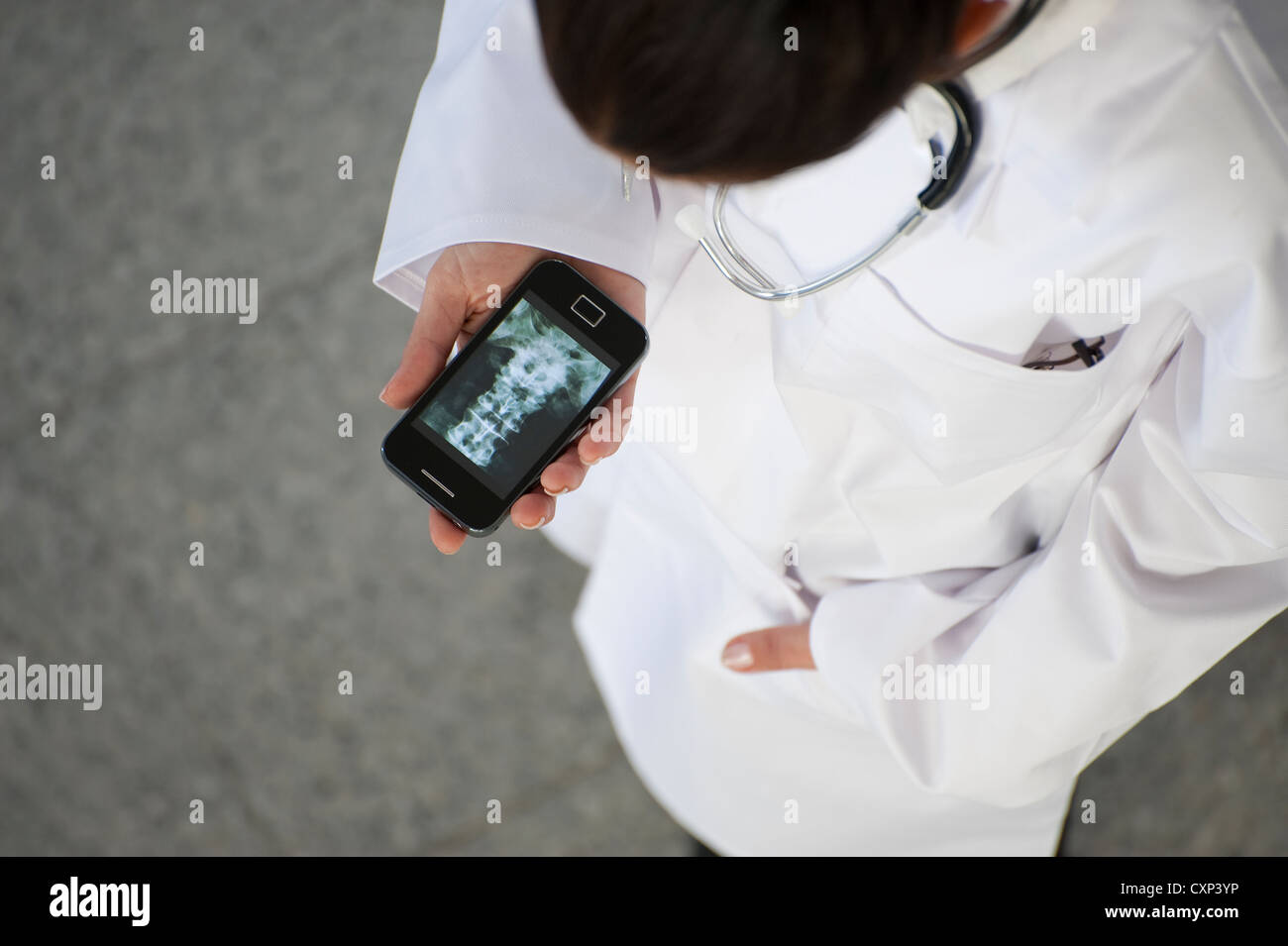 Ärztin, Blick auf Röntgenbild auf smartphone Stockfoto