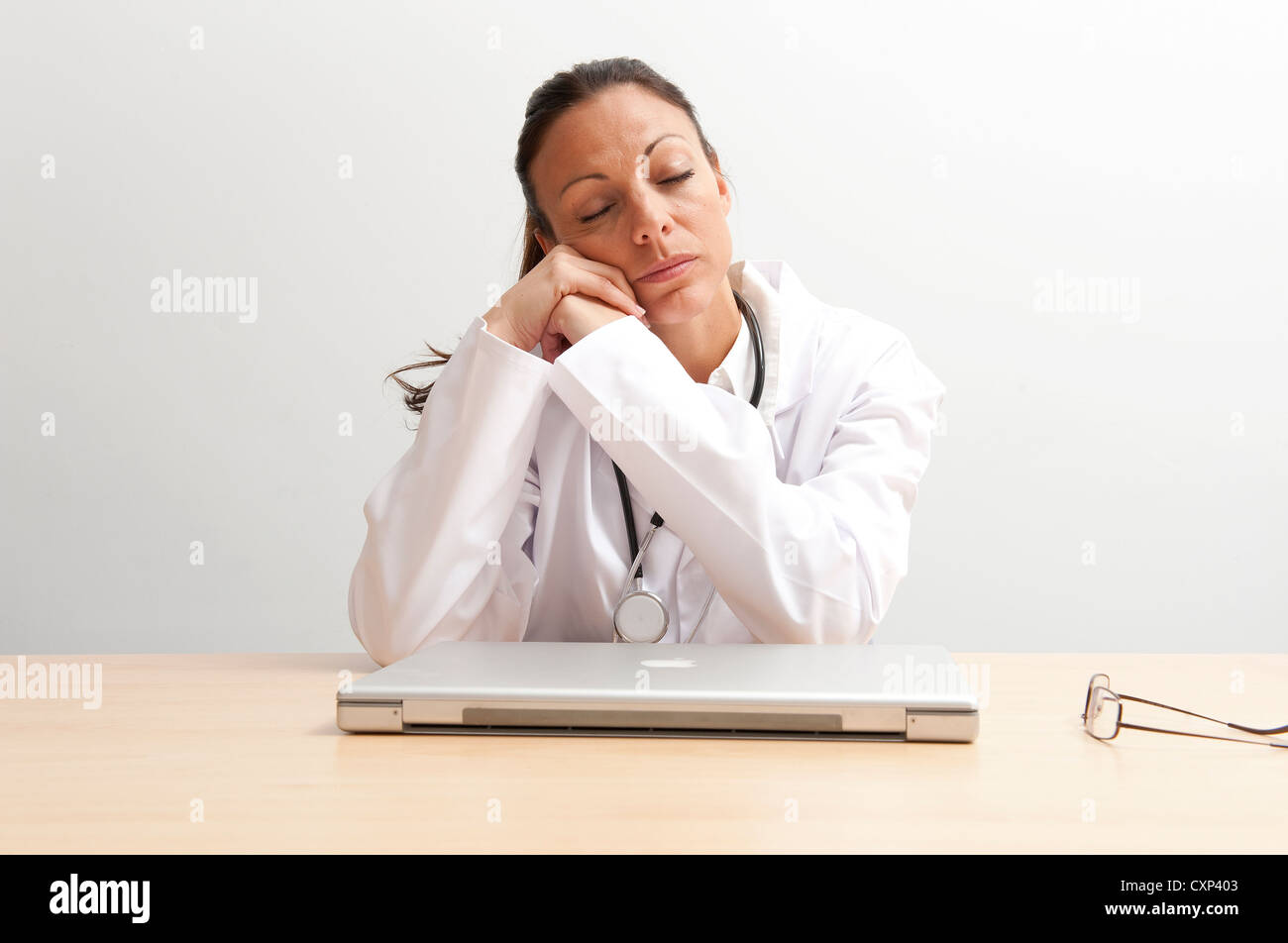 Ärztin, schlafen am Schreibtisch Stockfoto