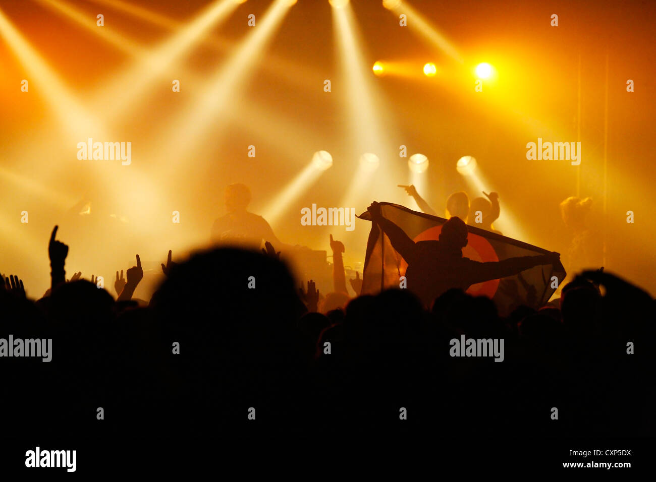 Silhouetted Zuschauer/Masse und Ambiente während live Rock Konzert mit Rocker auf der Bühne durch Strahler beleuchtet Stockfoto
