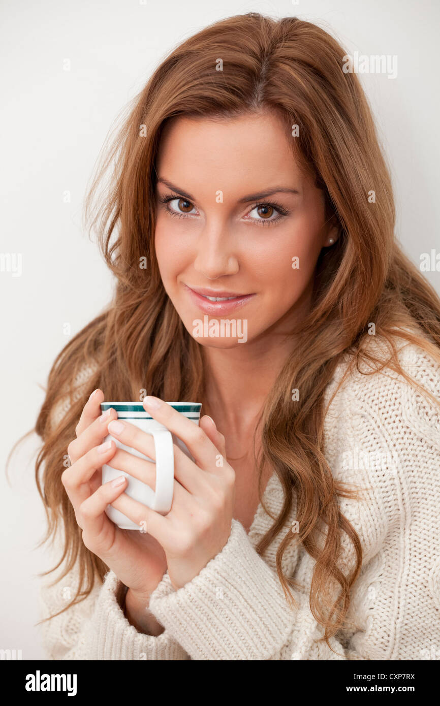 Portrait von eine schöne junge Frau mit einer Tasse oder Becher Kaffee oder Tee Stockfoto